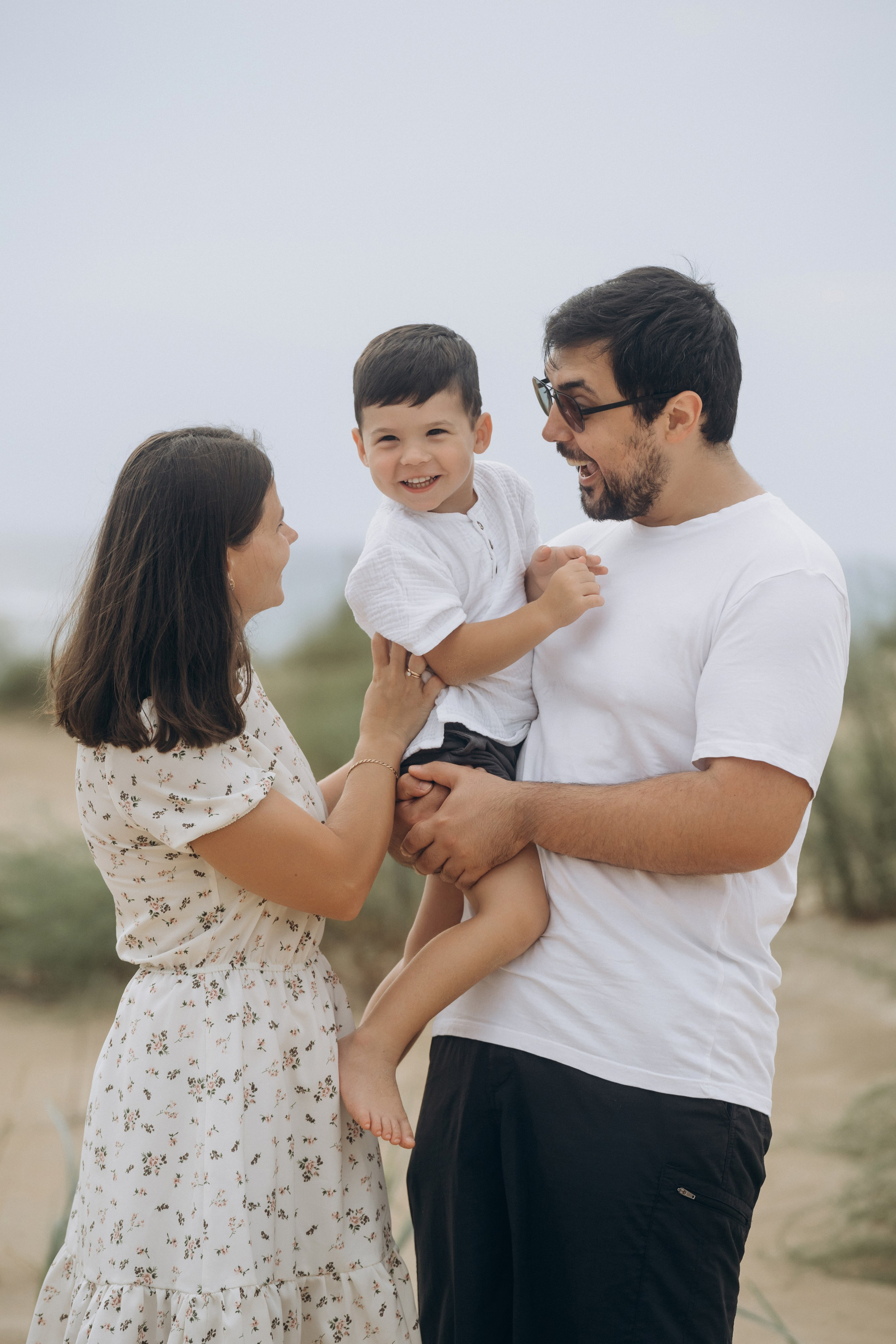 Анапская фотосессия – родители обнимают ребенка на фоне лазурного моря, фотограф Анапа