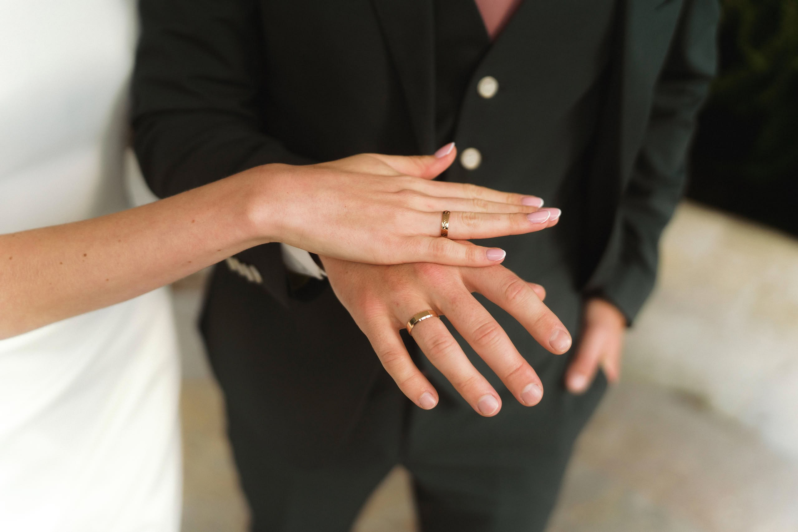 Крупный план рук на фоне зелени Польского сада, свадебная прогулка.