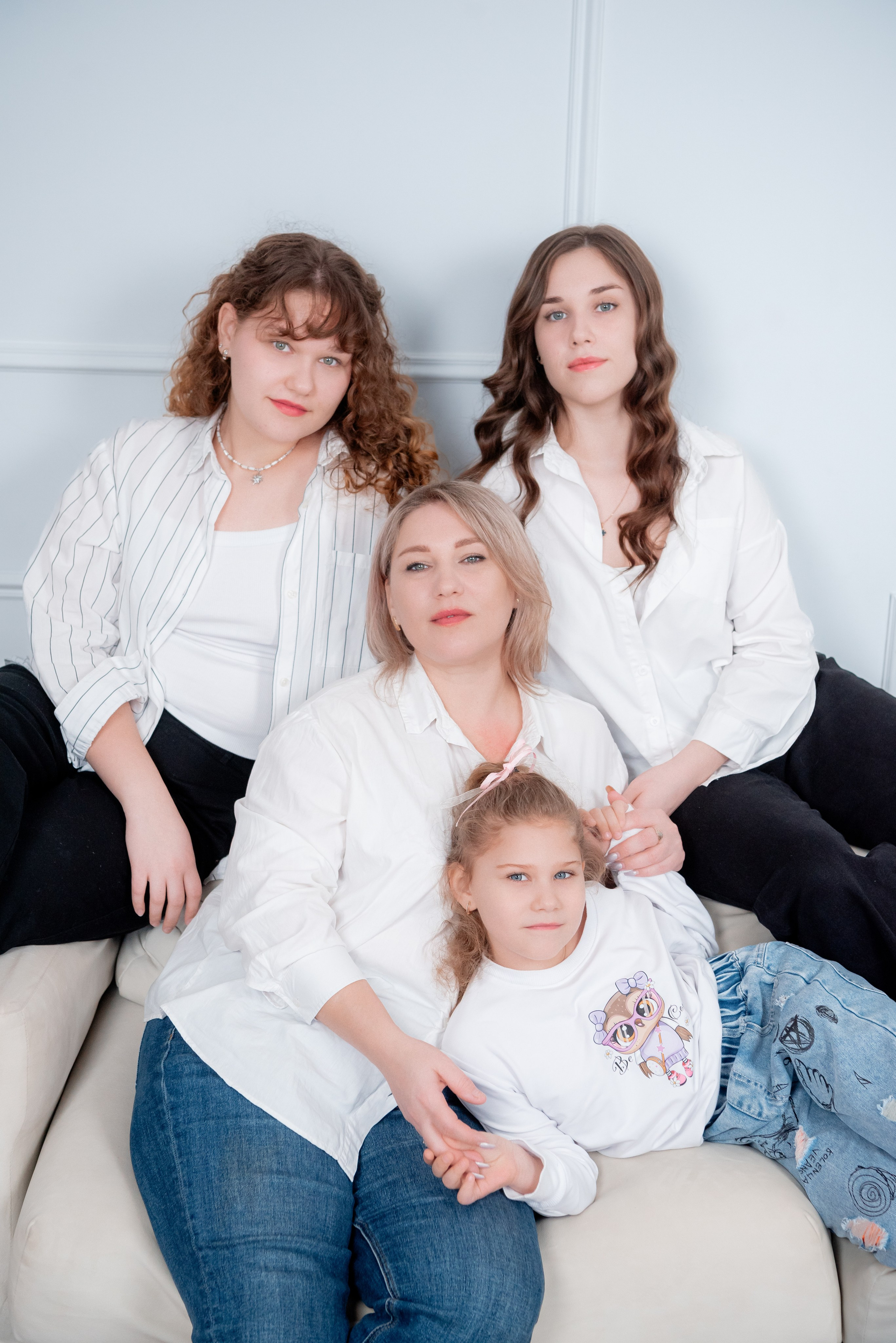 Фото мамы с взрослыми дочерьми в студии Joy: все в едином стиле, двое в синих джинсах, двое в черных.