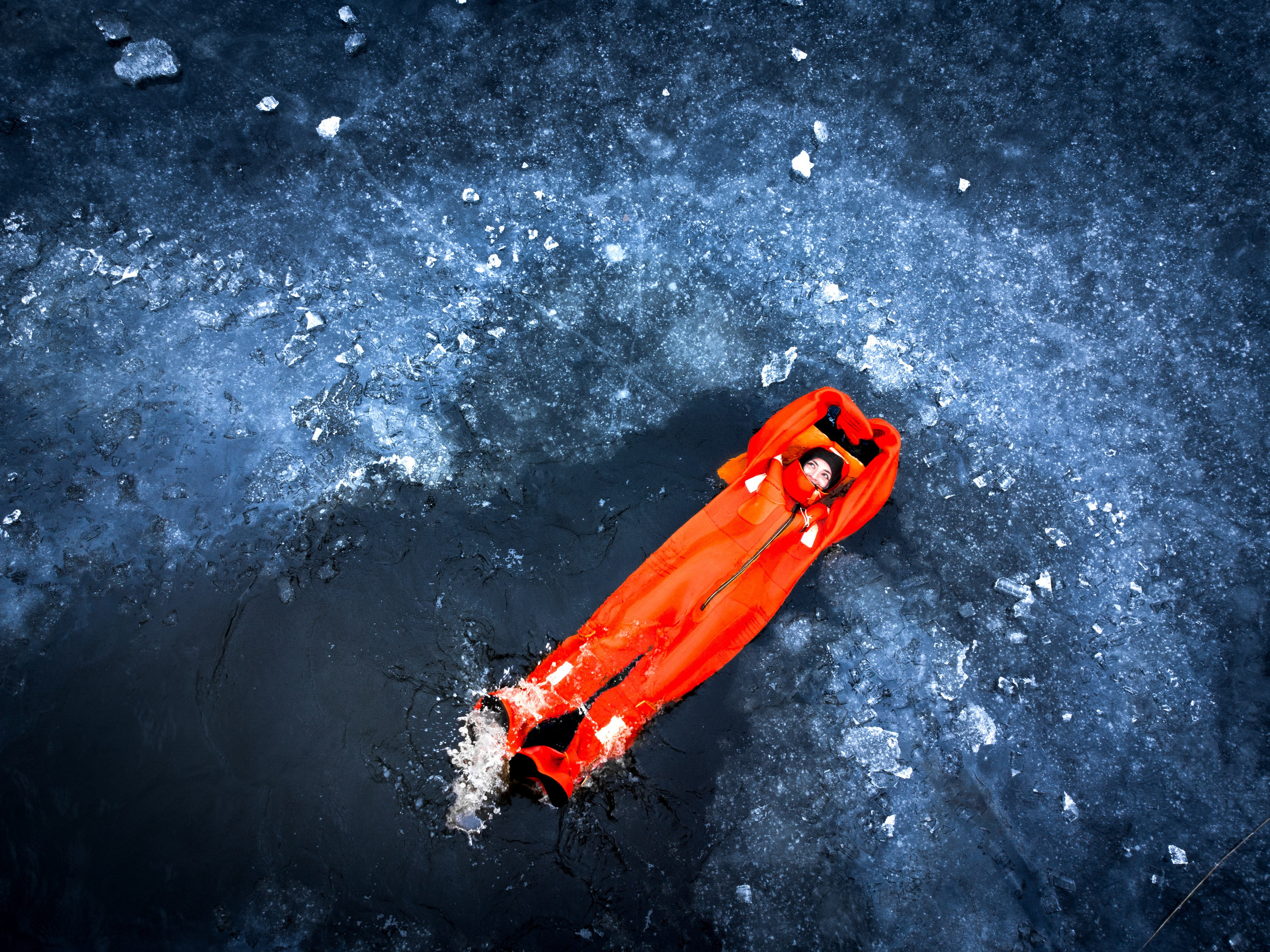 Люди купаются среди льдин, в спасательных оранжевых термо костюмах, айс флоатинг Ярославль