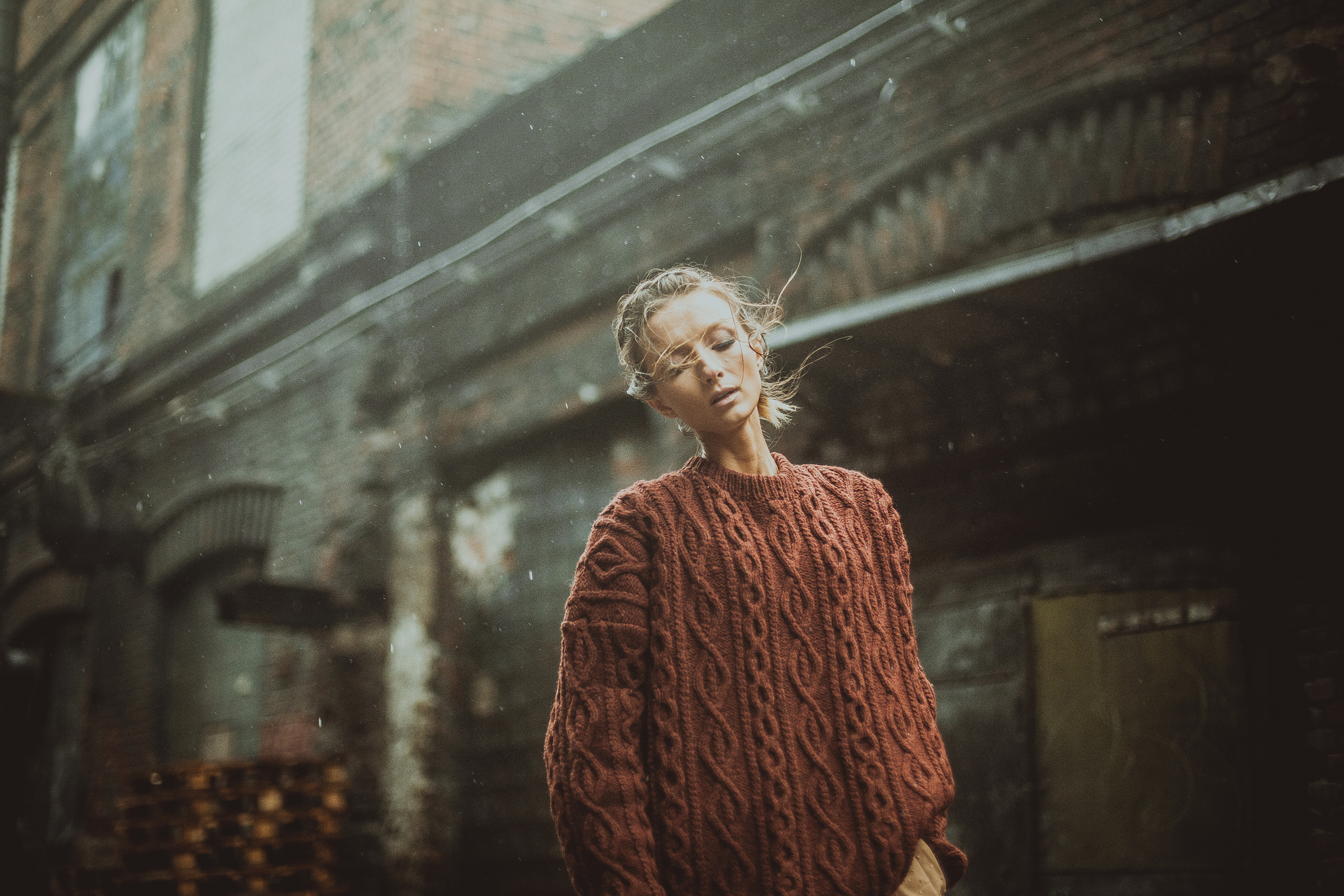 девушка в вязаном свитере в дождь в старом квартале города