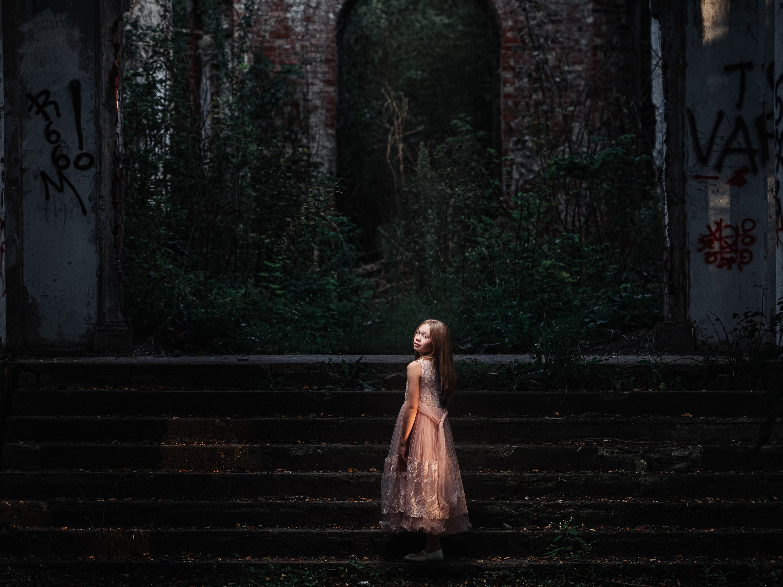 Девочка в нарядном платье вечером в развалинах усадьбы