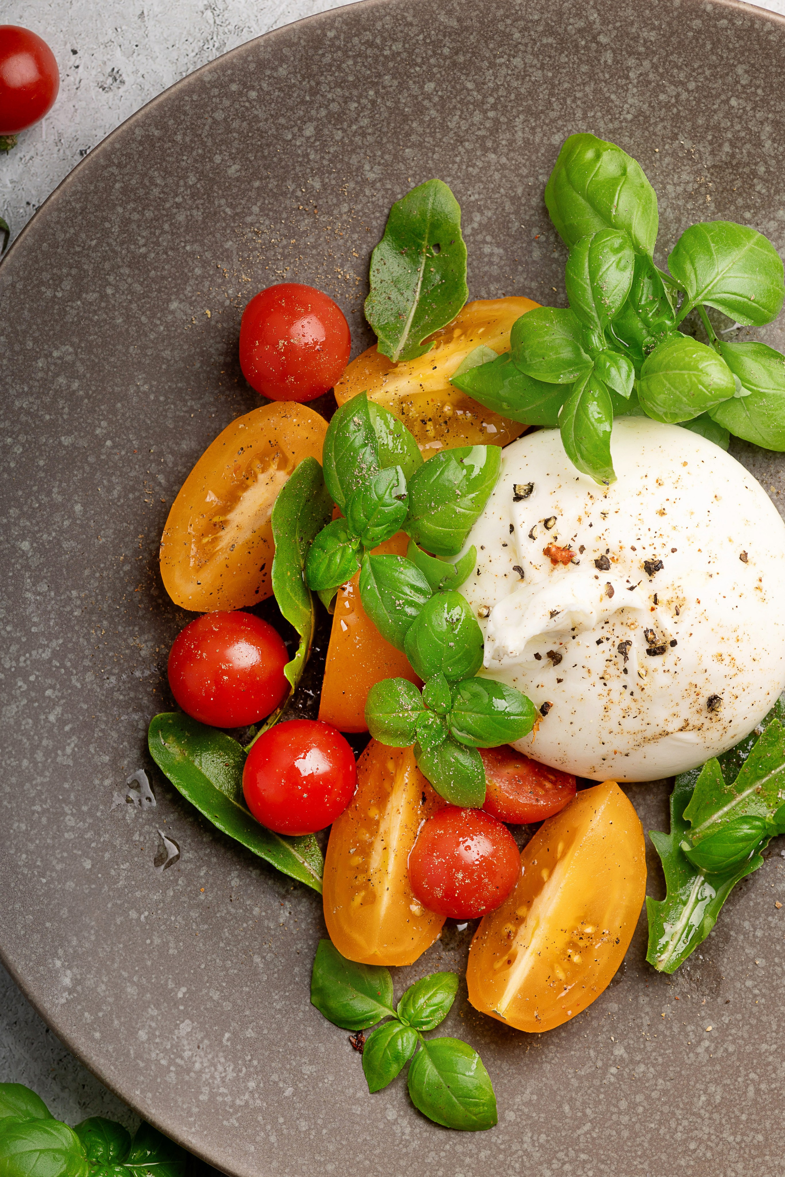 Фудстайлинг салата из сыра буратто и томатов. Фудсъемка для меню ресторана