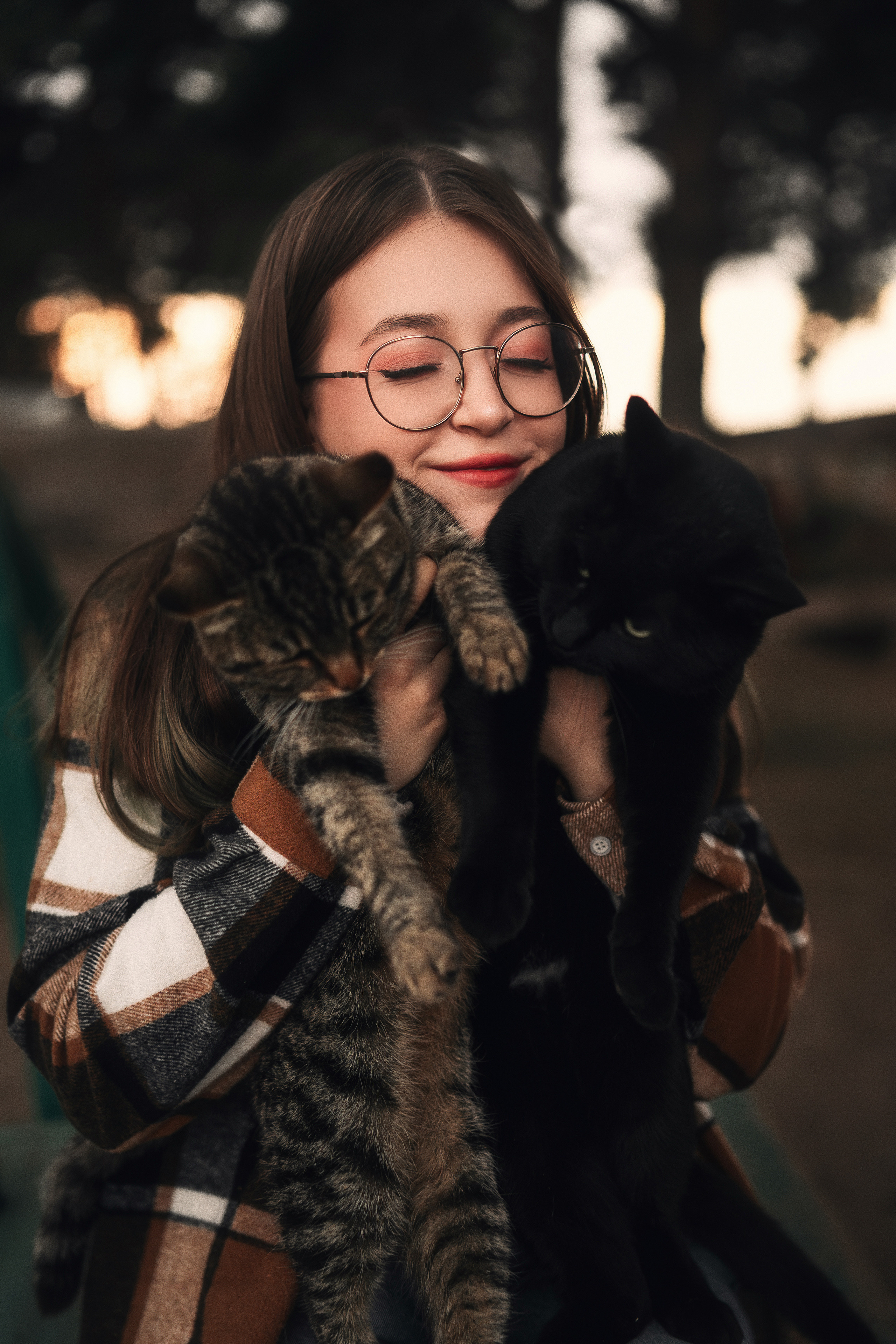 Девушка с котиками обнимается.