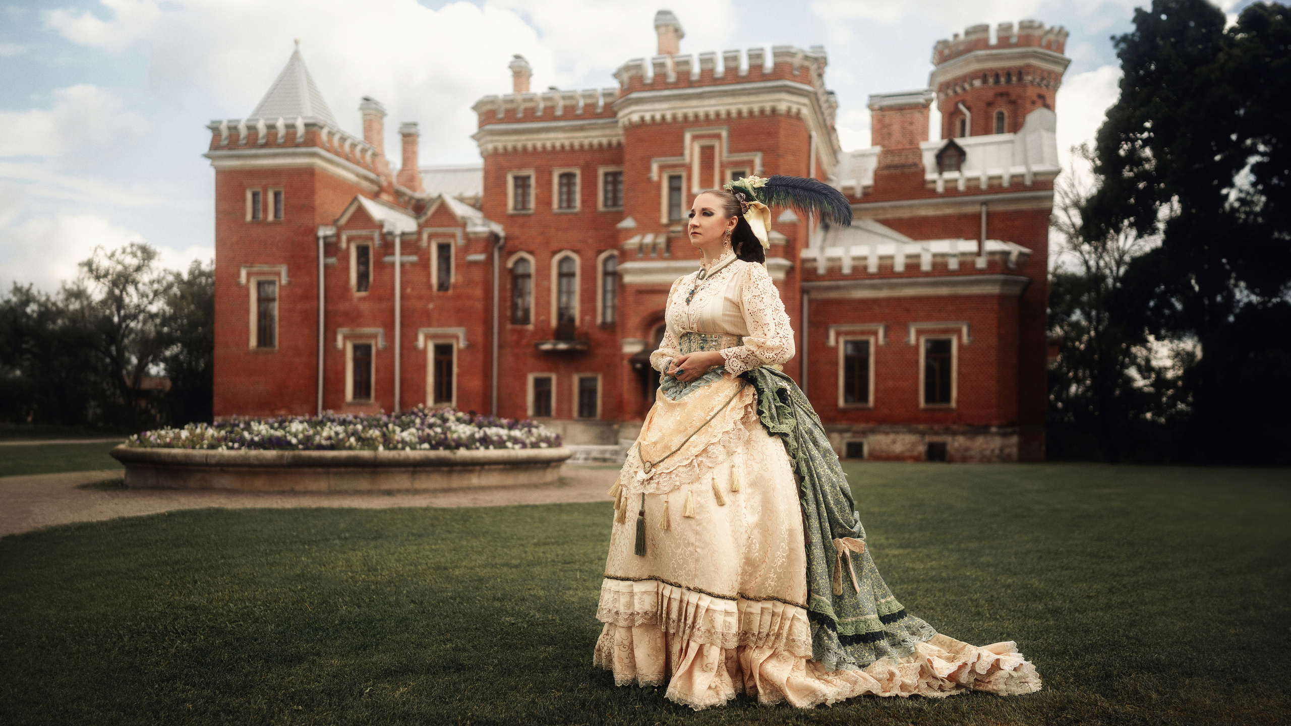 Девушка в шикарном, историческом платье на фоне исторического замка.