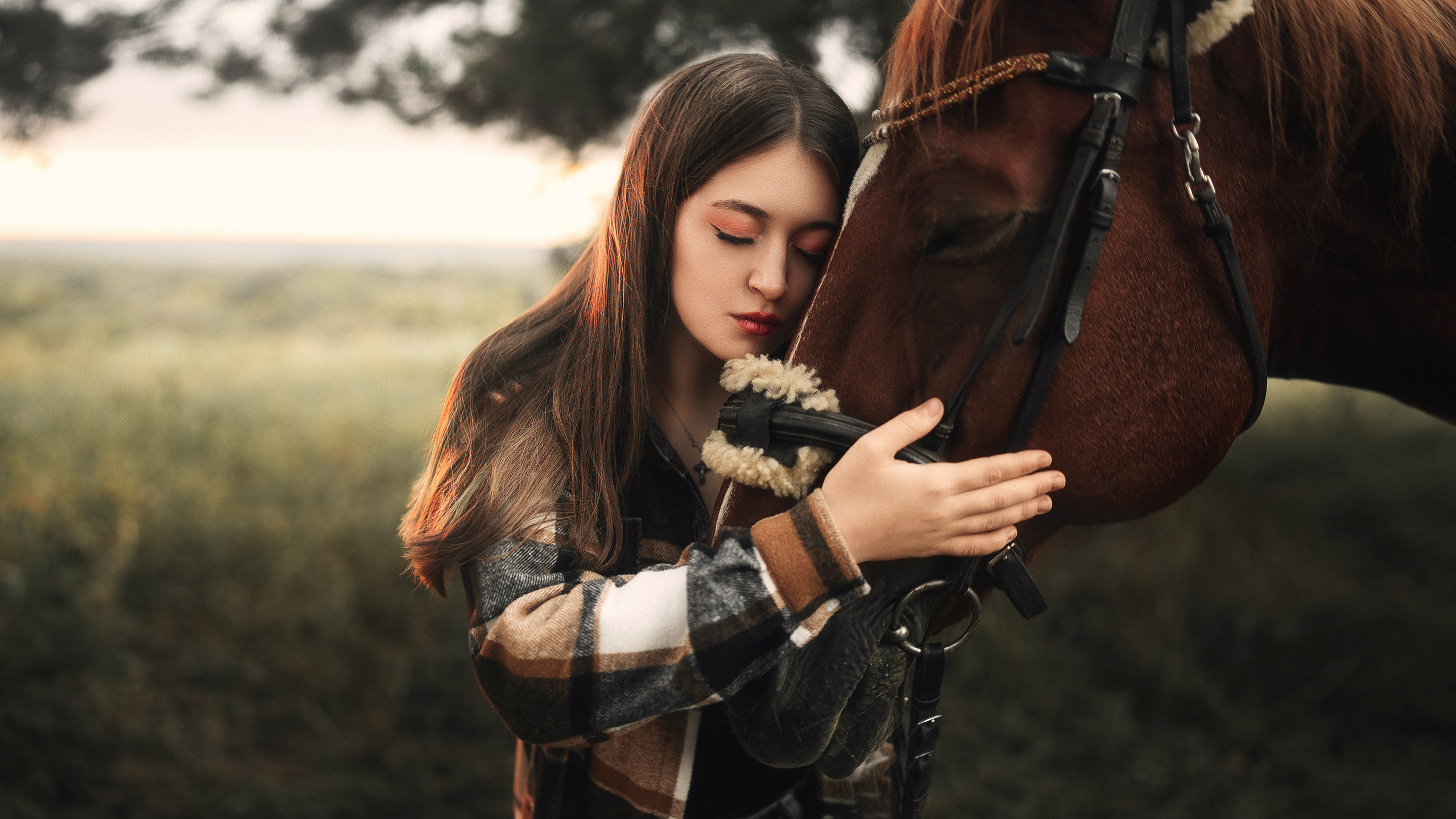 Красивая девушка обнимает лошадь.