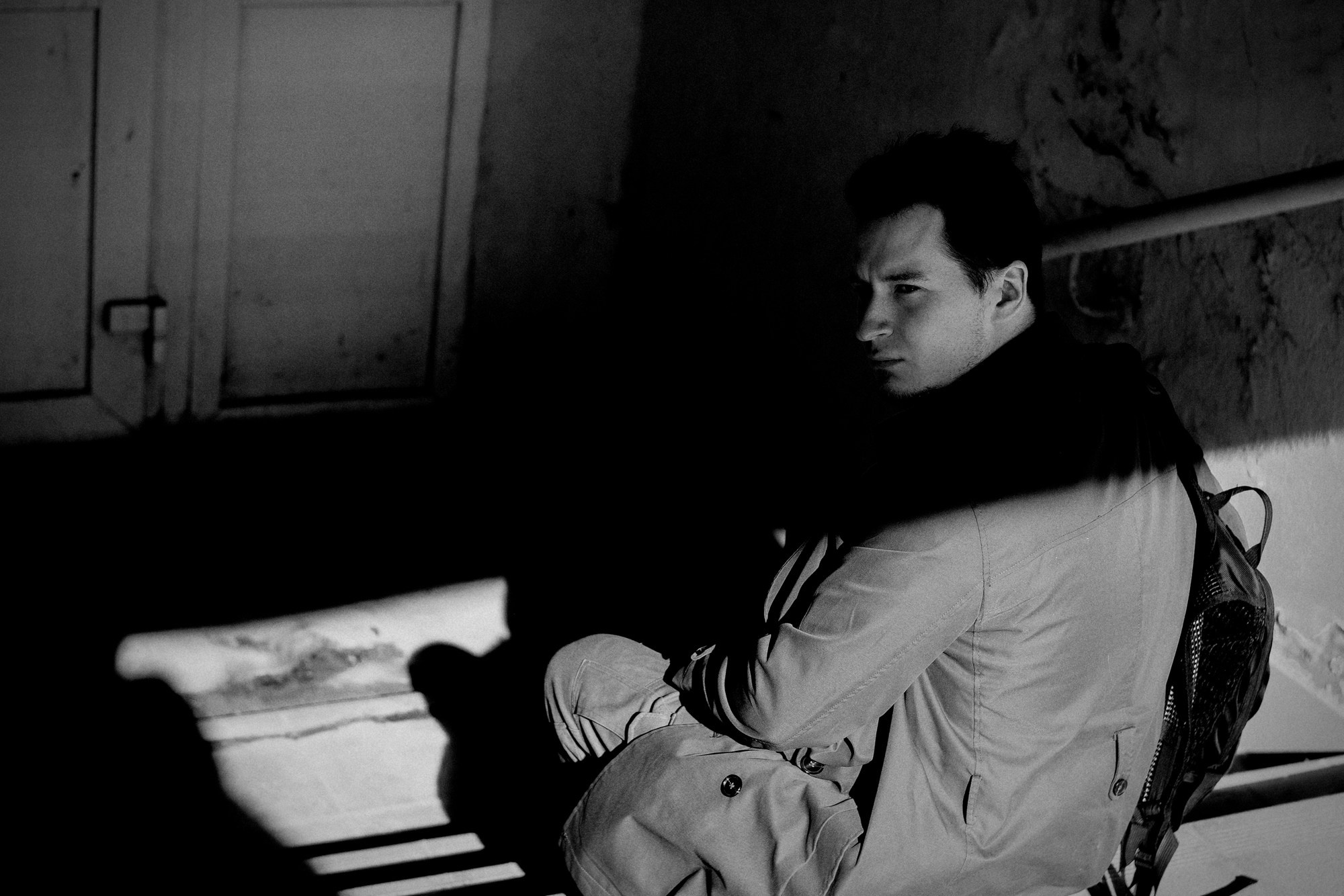 Черно-белый портрет мужчины в пальто, серьезный взгляд