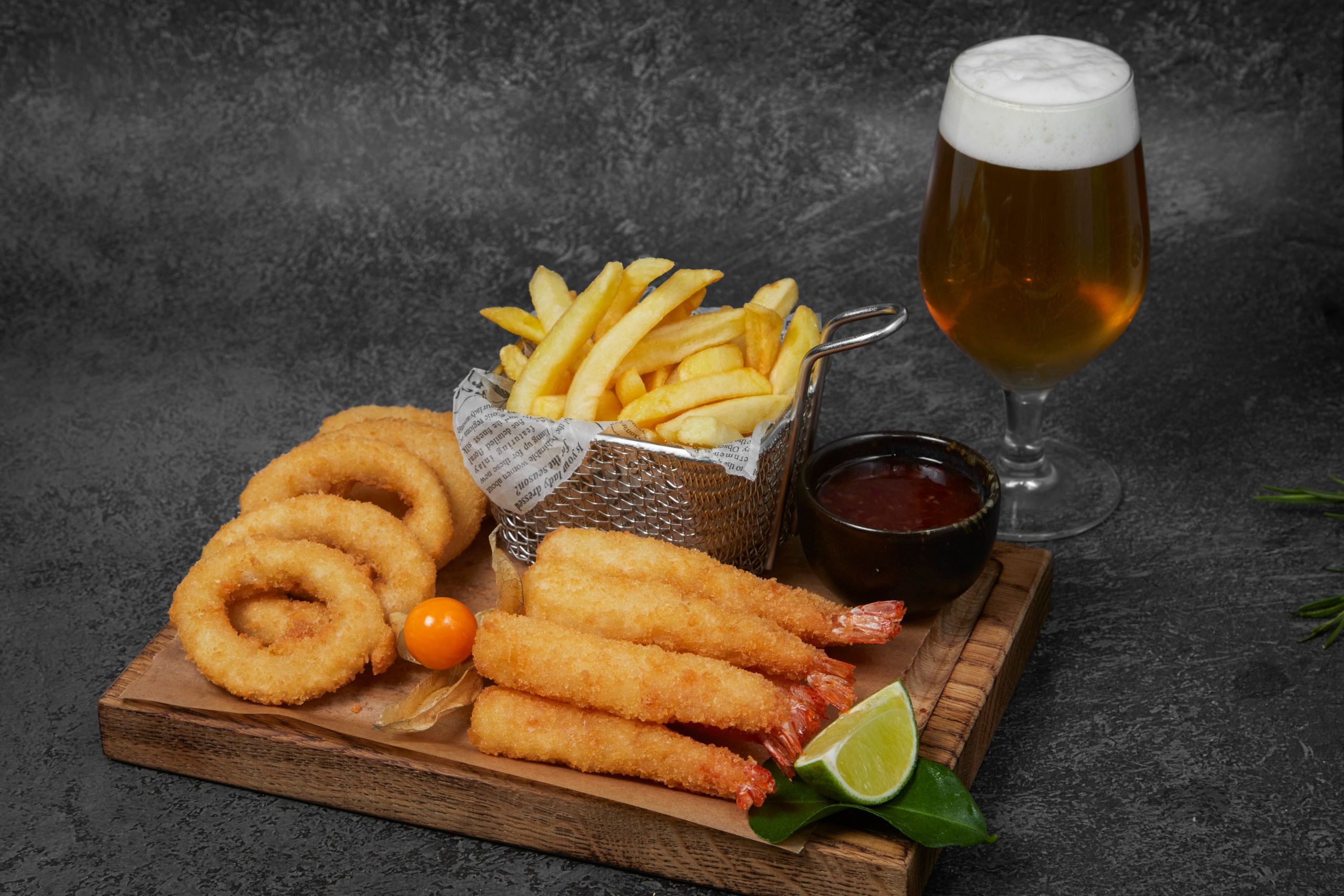 Ассорти закусок: картофель фри и кольца кальмара с соусом.