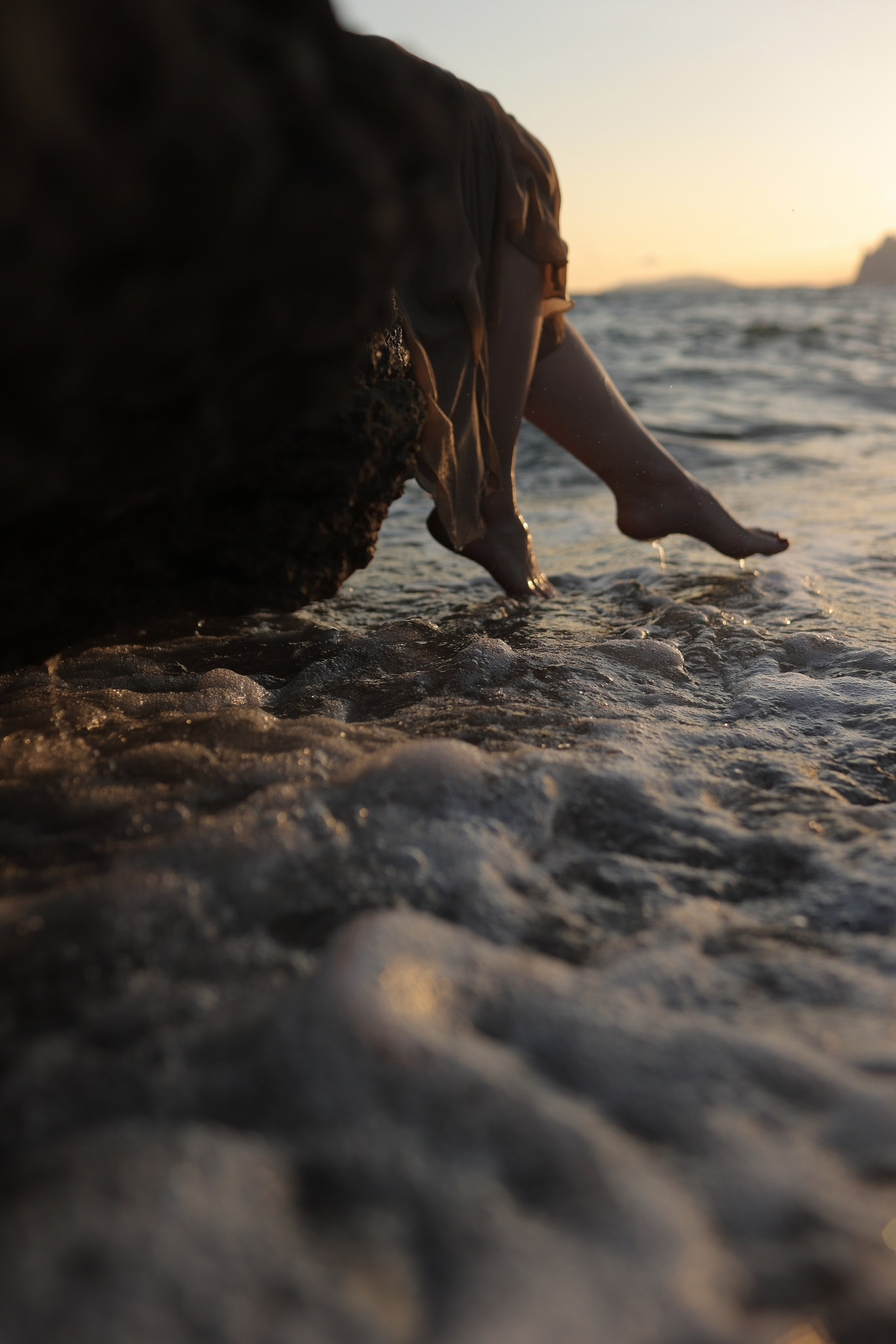 Плискает девушка ноги в воде