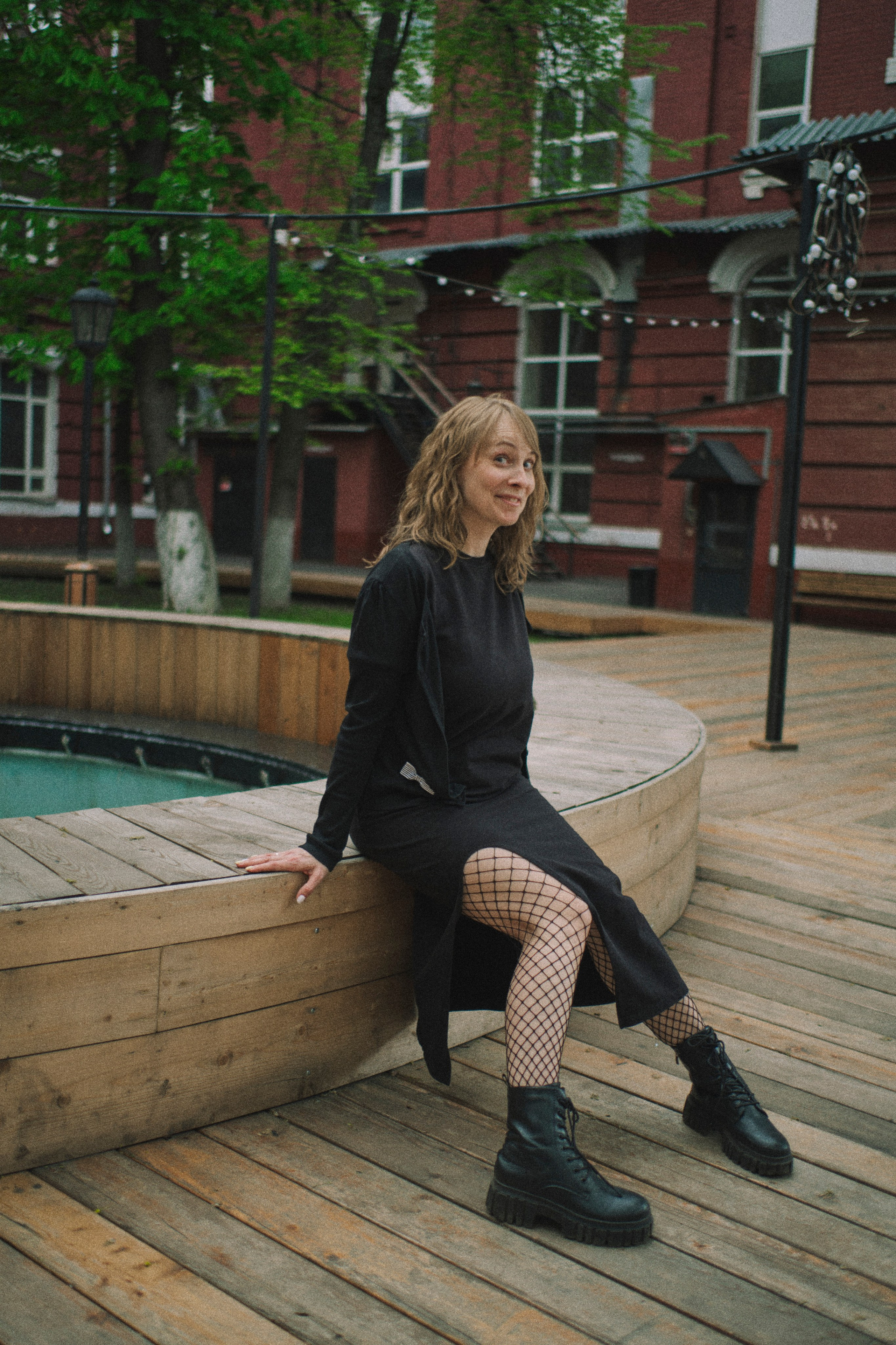 Девушка сидит у фонтана