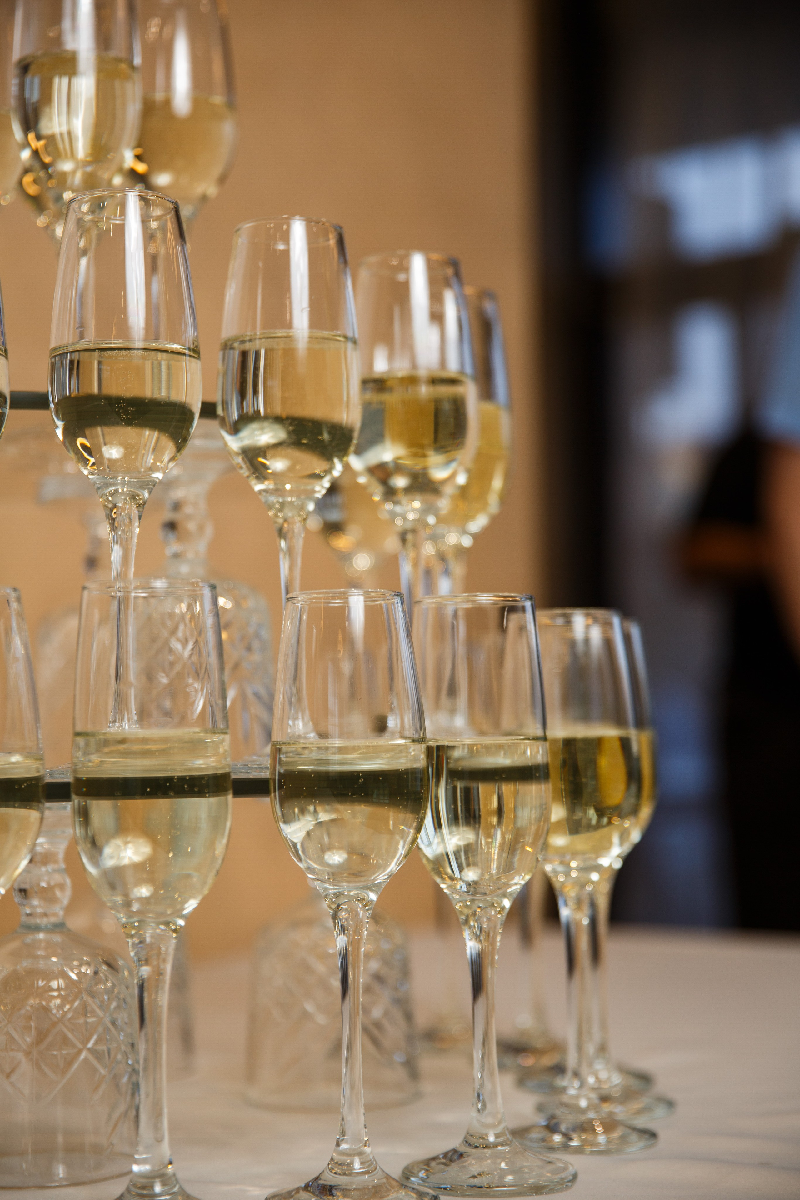 Женщина в белом праздничном костюме позирует в ресторане.