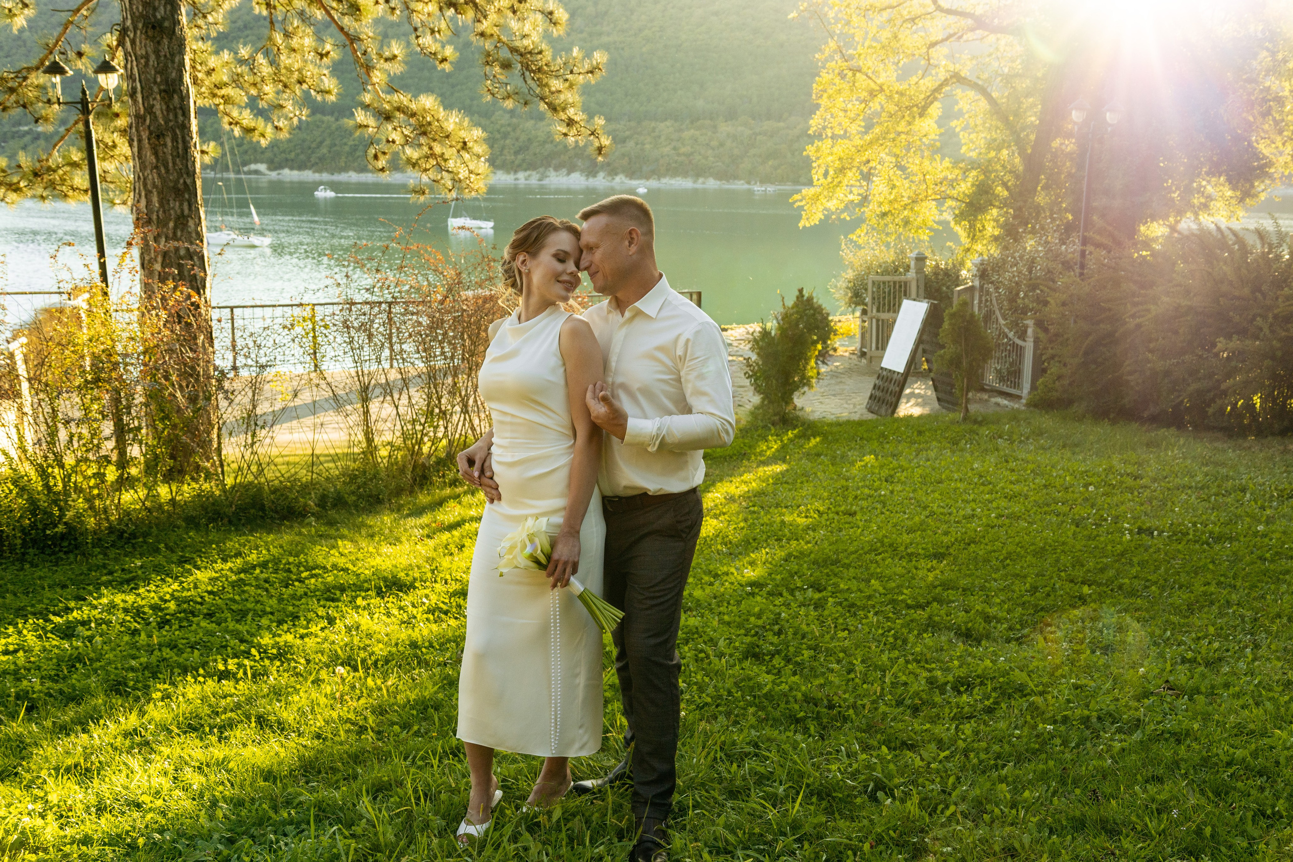 Нежный поцелуй молодоженов на закате у озера Абрау-Дюрсо
