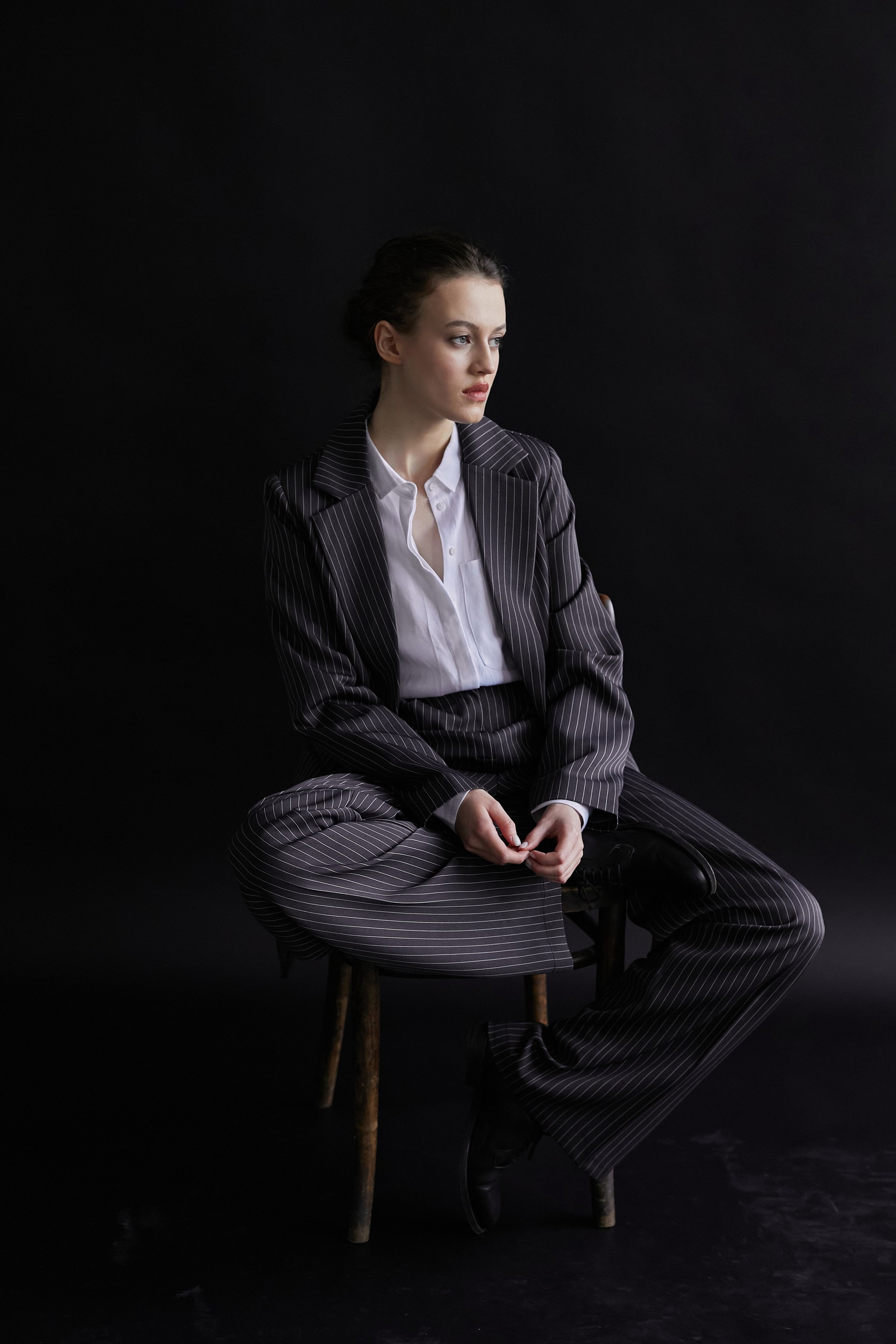 Фотограф в Москве. Студия. Студийный портрет. Девушка в пиджаке. Девушка на стуле на черном фоне. Красивая девушка в мужском костюме. Женский портрет.