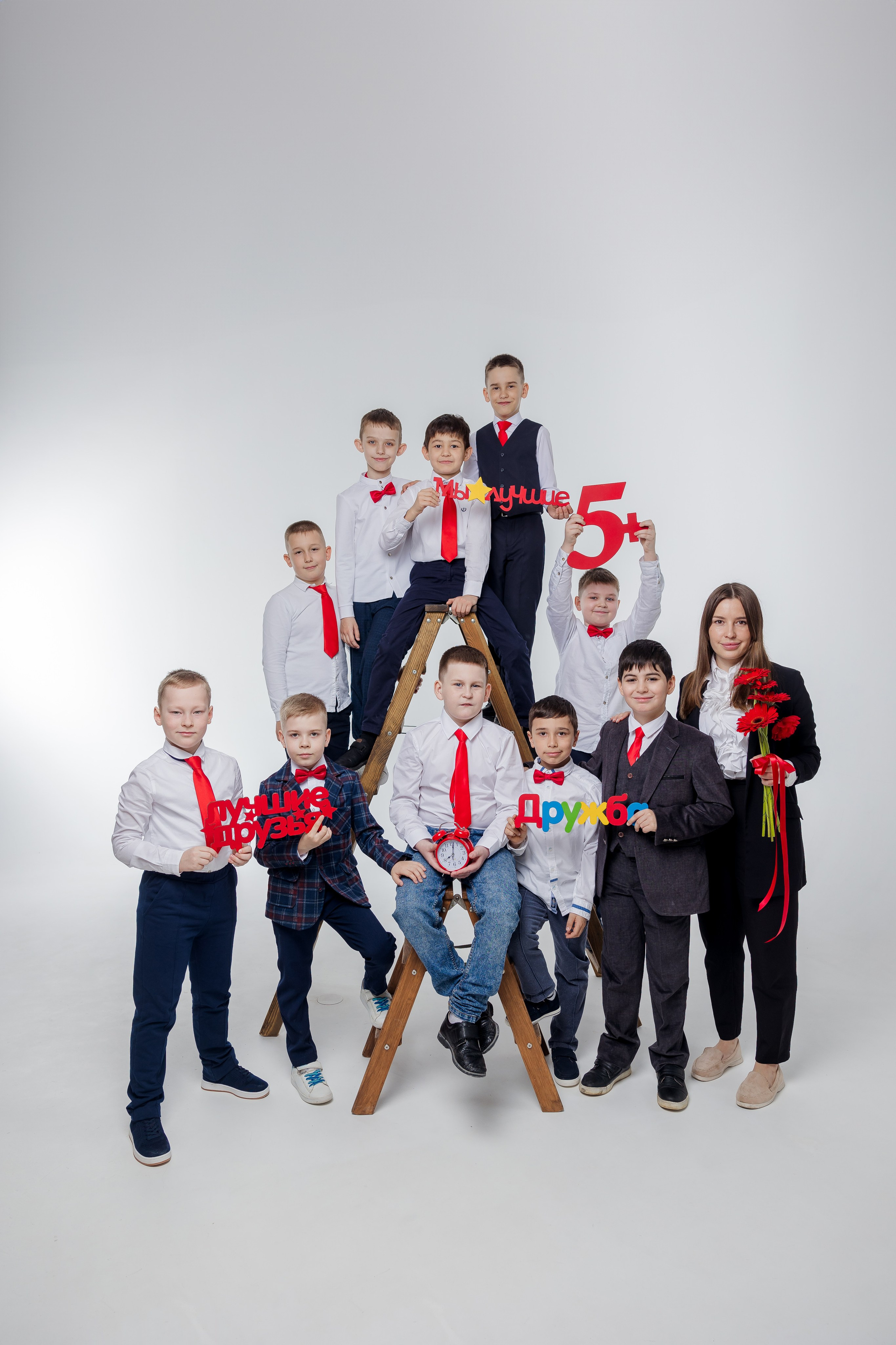 Мальчики стоят с учителем на деревянной лестнице