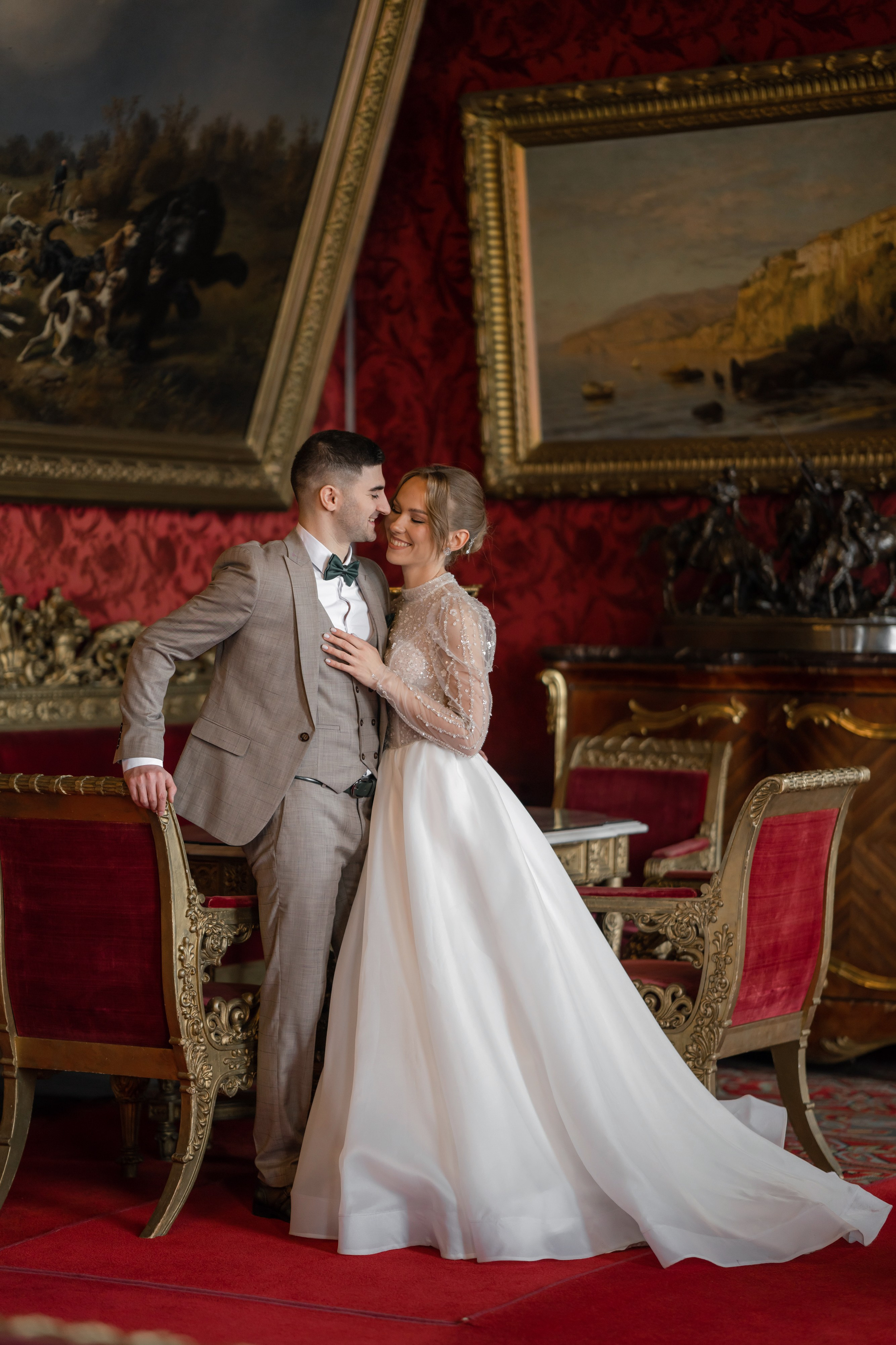 Невеста и жених целуются во Дворце Великого князя Владимира с красной гостиной
