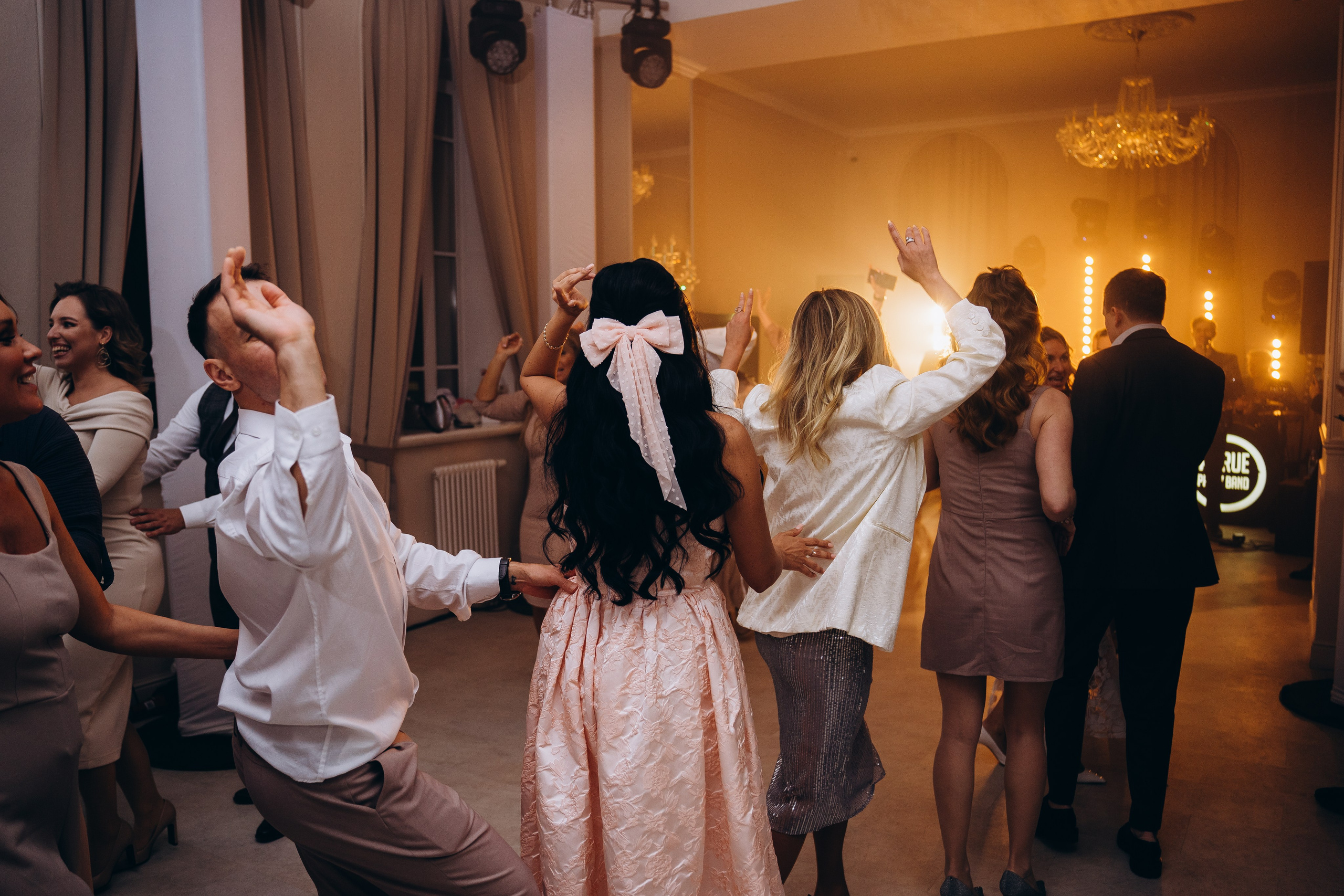 Веселые гости танцуют на свадебном банкете — репортажная съемка свадебных мероприятий в Москве с живыми эмоциями.