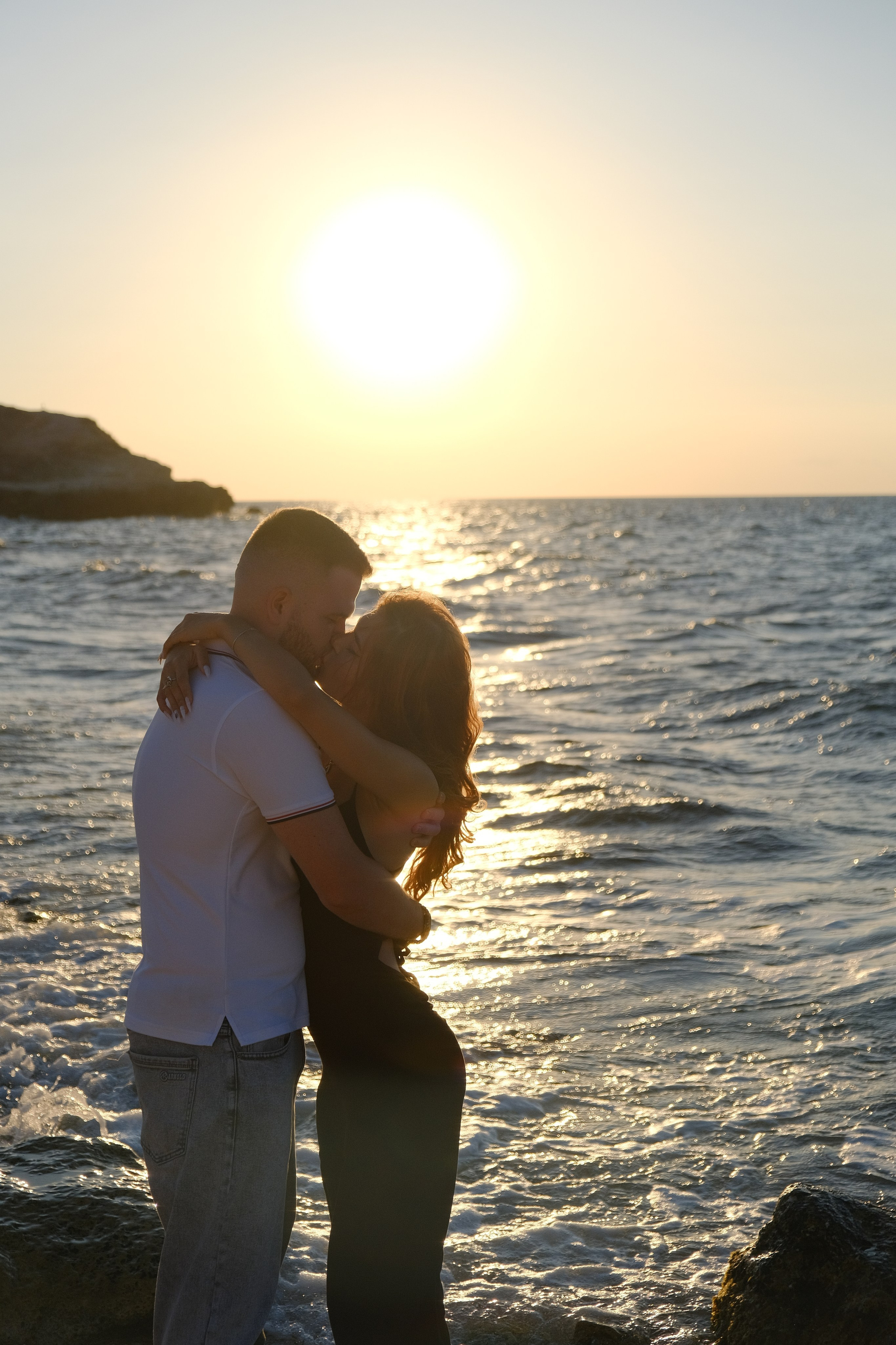 Прекрасная парочка влюбленных молодых людей целуется на пляже Херсонеса таврического у моря. Фотограф и видеограф Желдак Илья