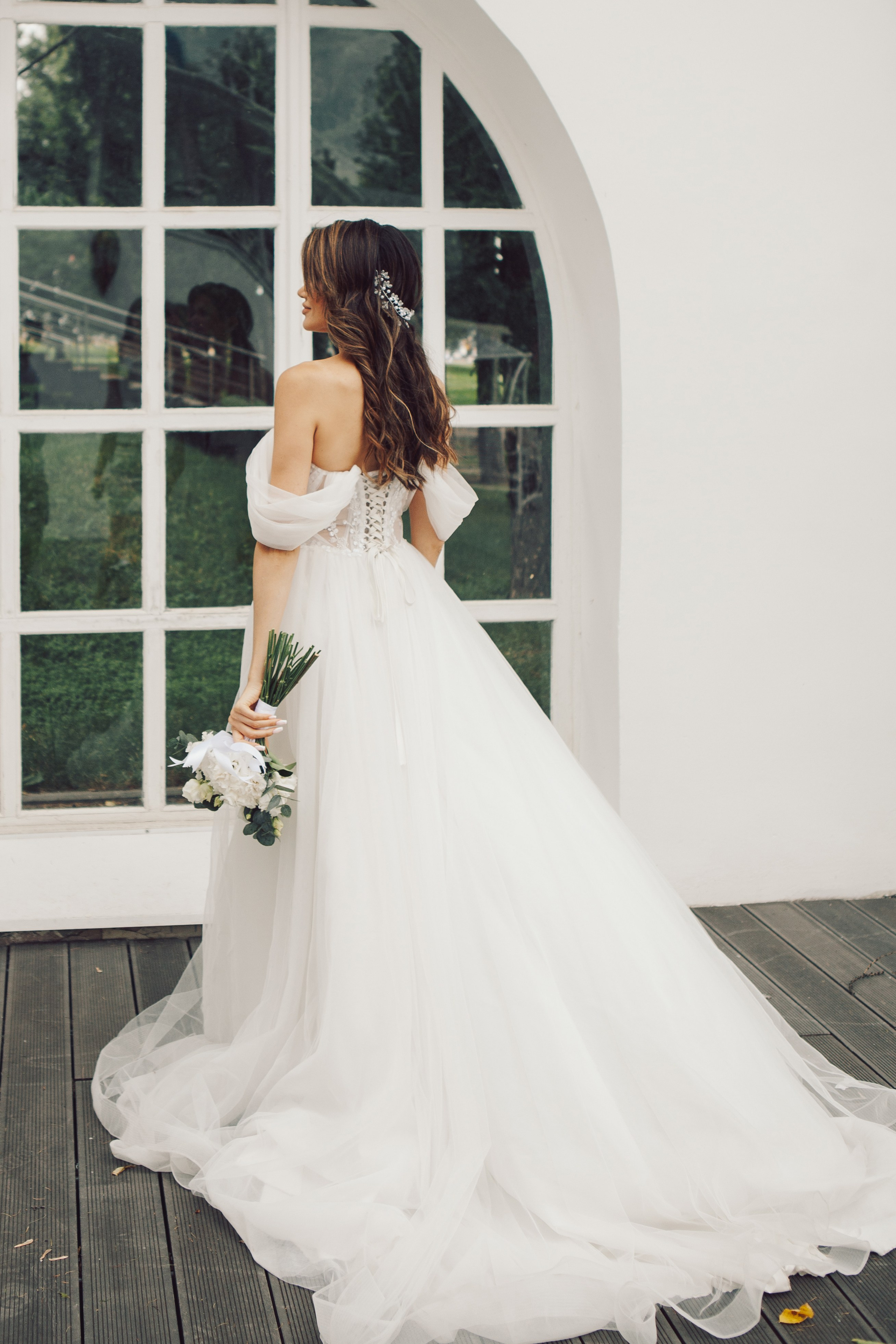 Фотосессия стильной невесты в длинном платье и с букетом на вднх у ресторана