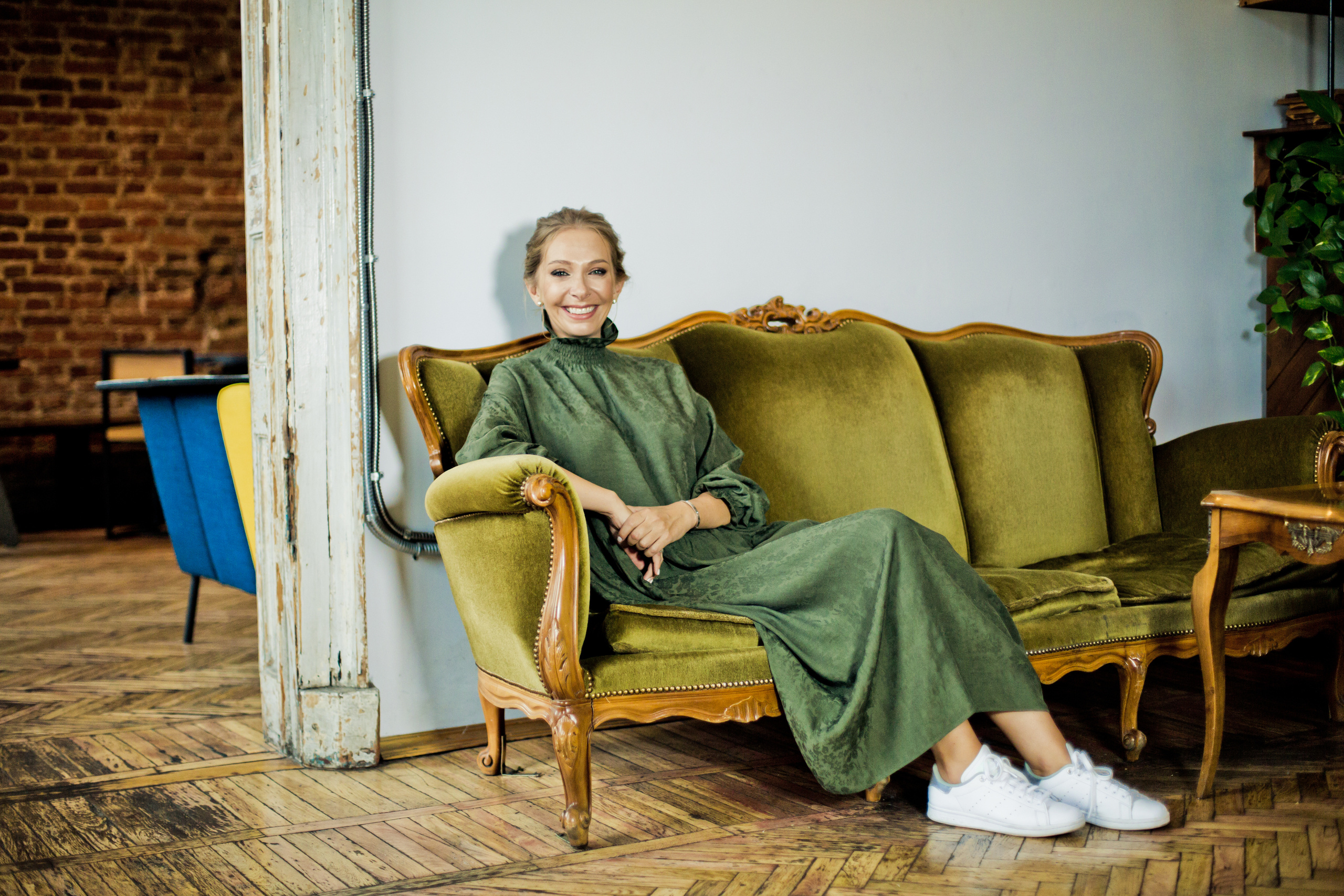 женщина в зеленом платье на старинном диване