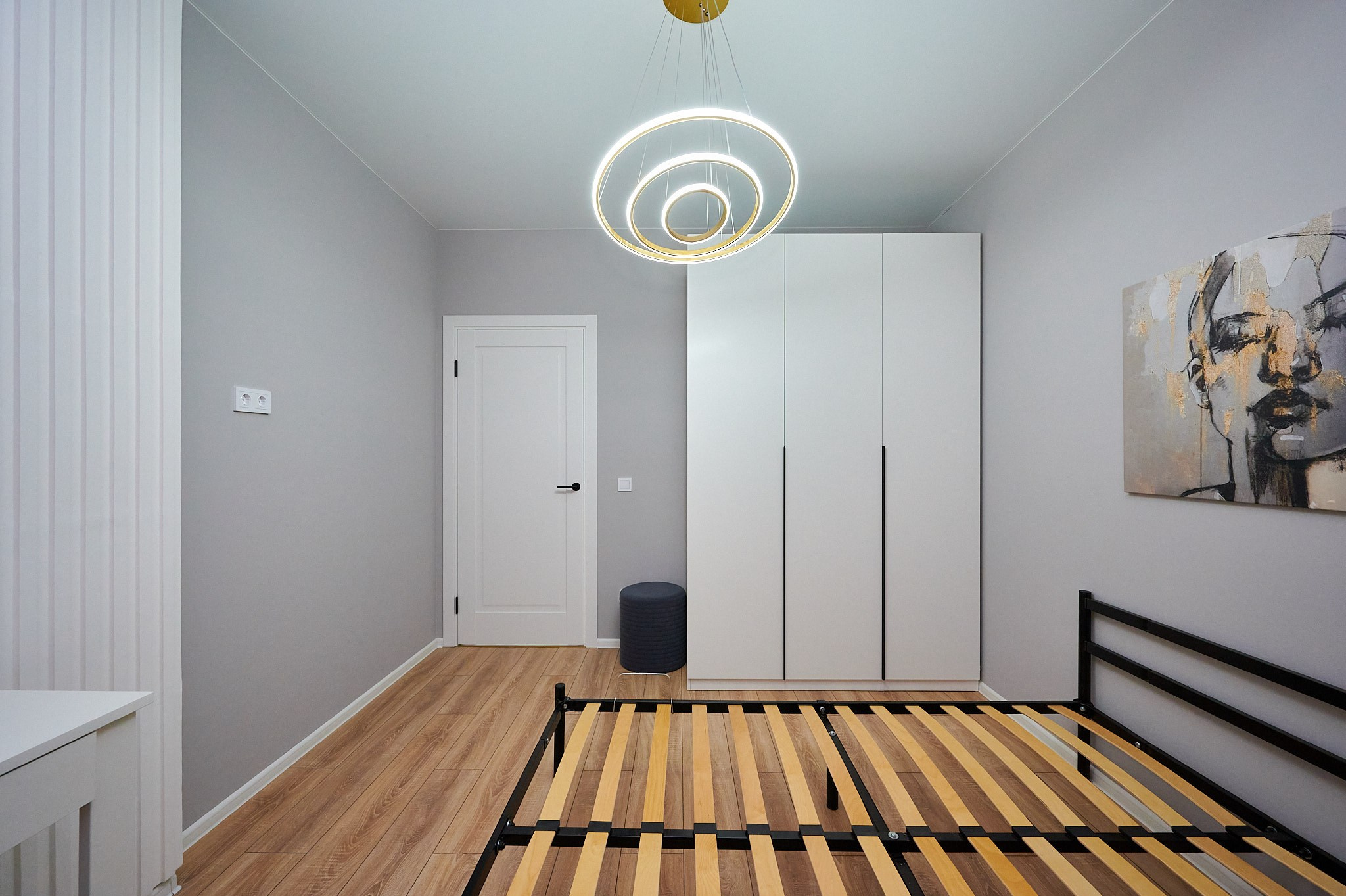 комната светлые стены кровать черная обводка белый шкаф 