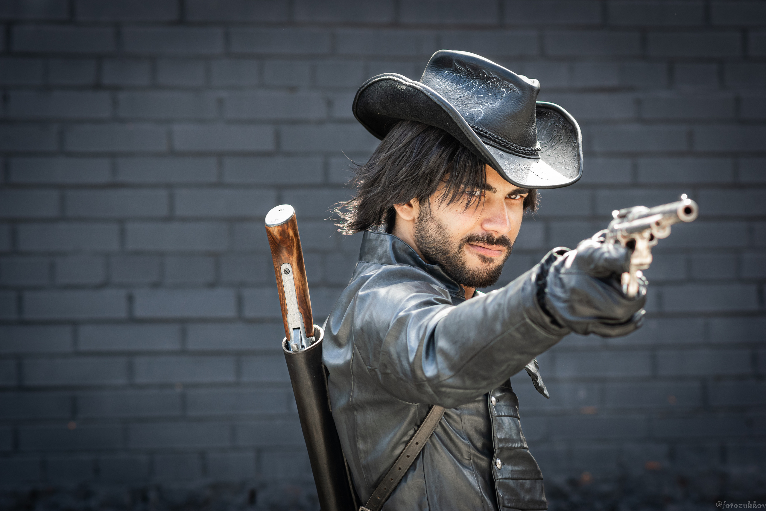 Мужчина в образе ковбоя с пистолетом и шляпе