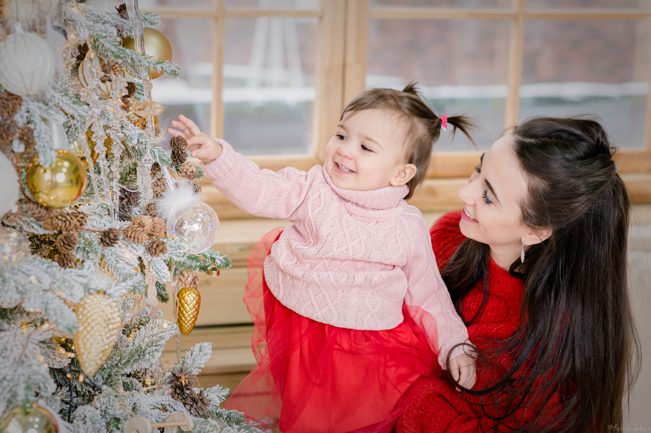 Мама с дочкой наряжают ёлочку