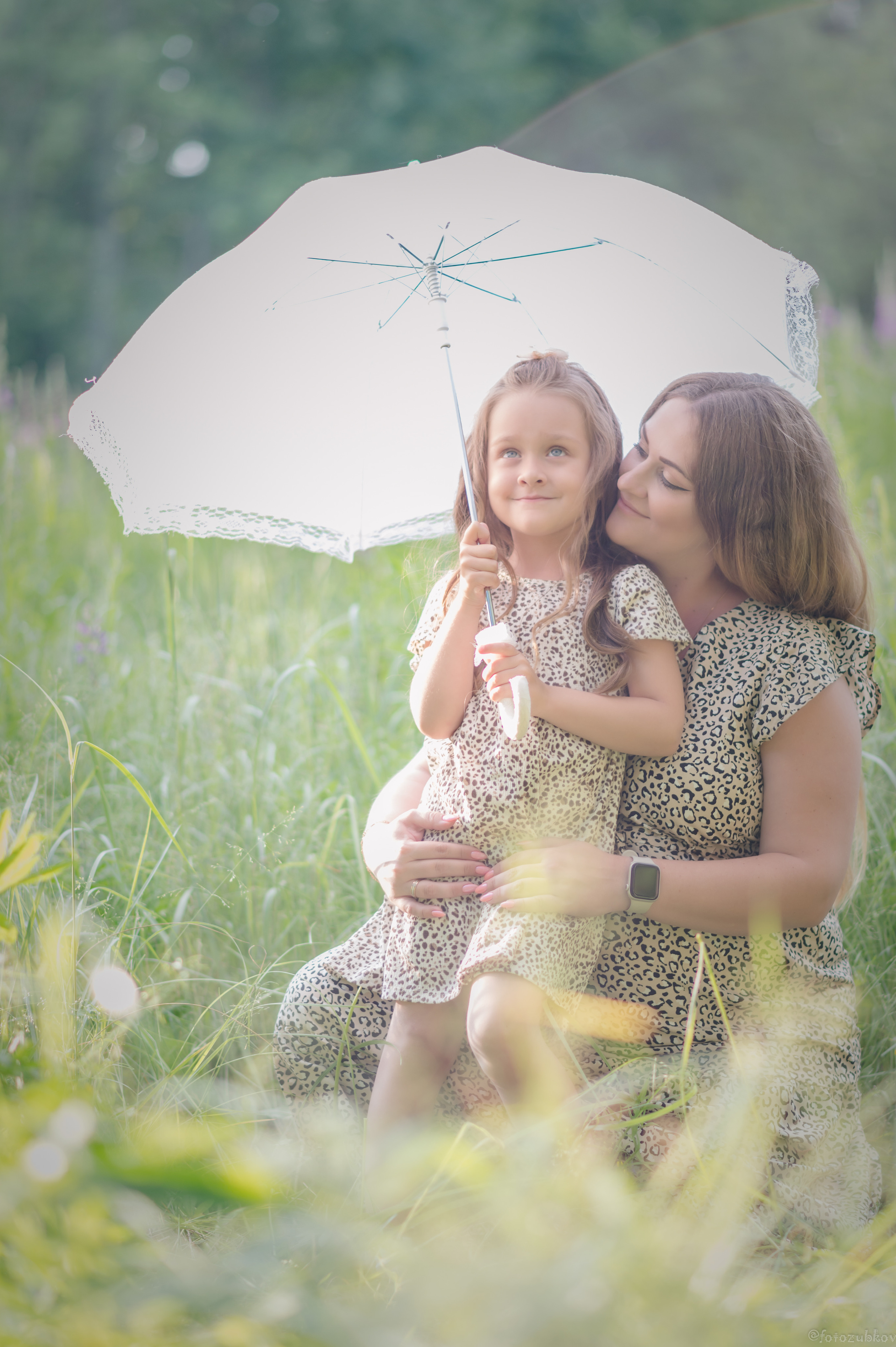 Мама с дочкой под зонтиком спасаются от жары