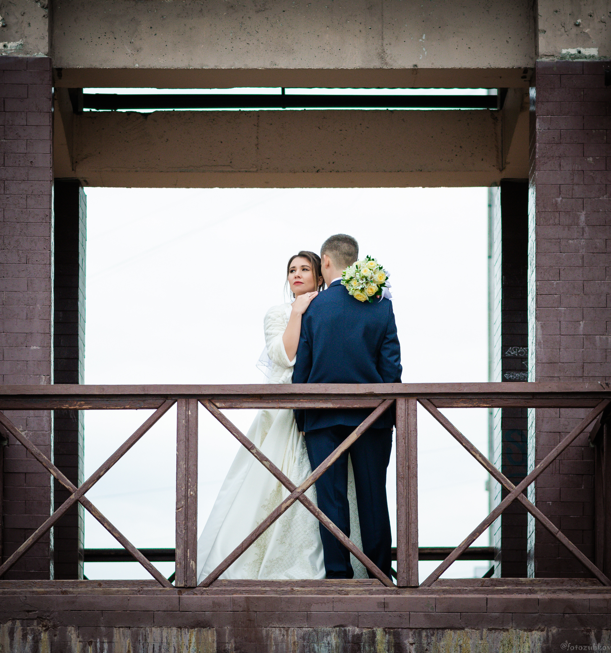 Невеста с женихом стоят на мостике