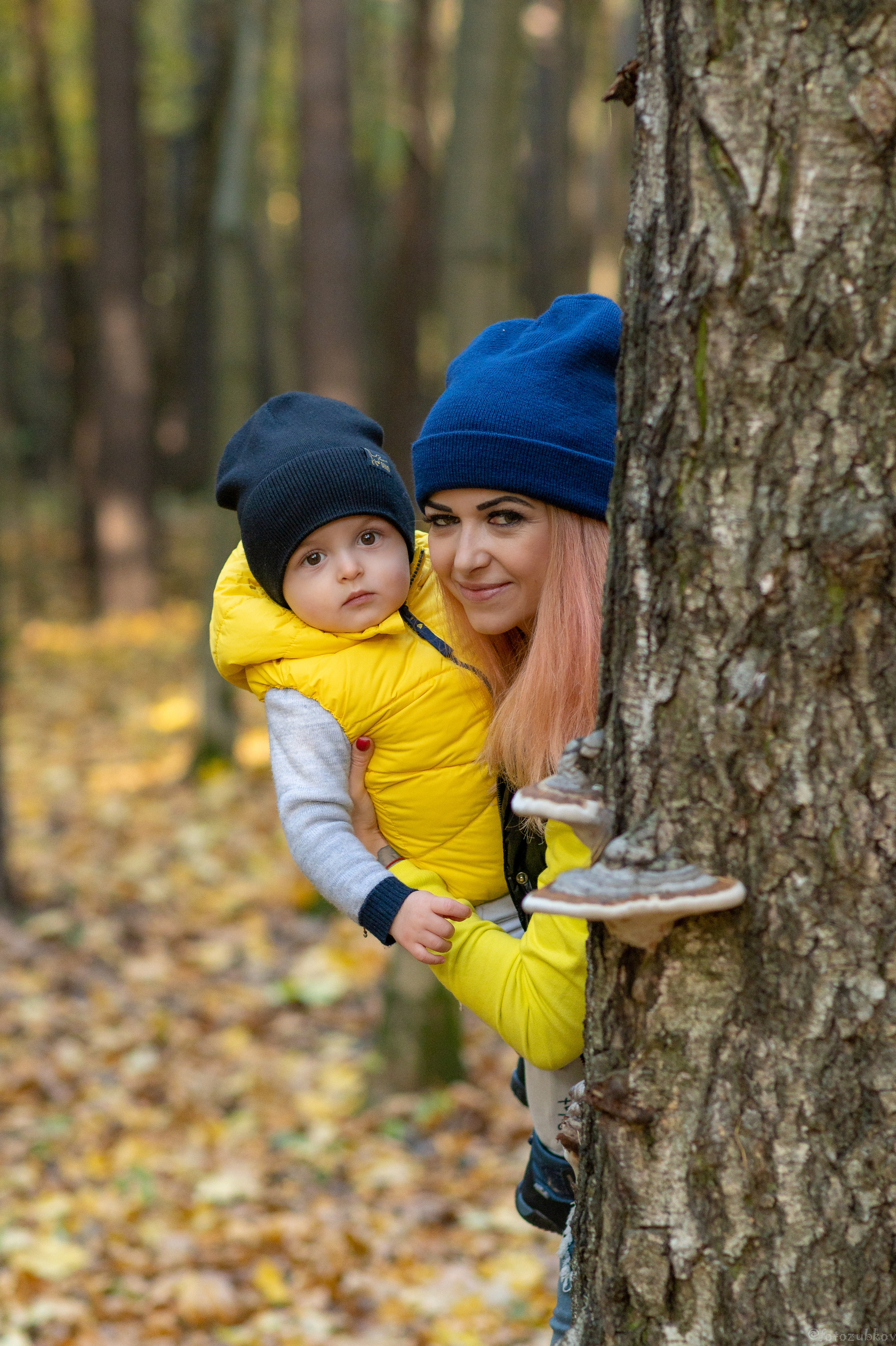Мама с сыночком выглядывают из-за дерева