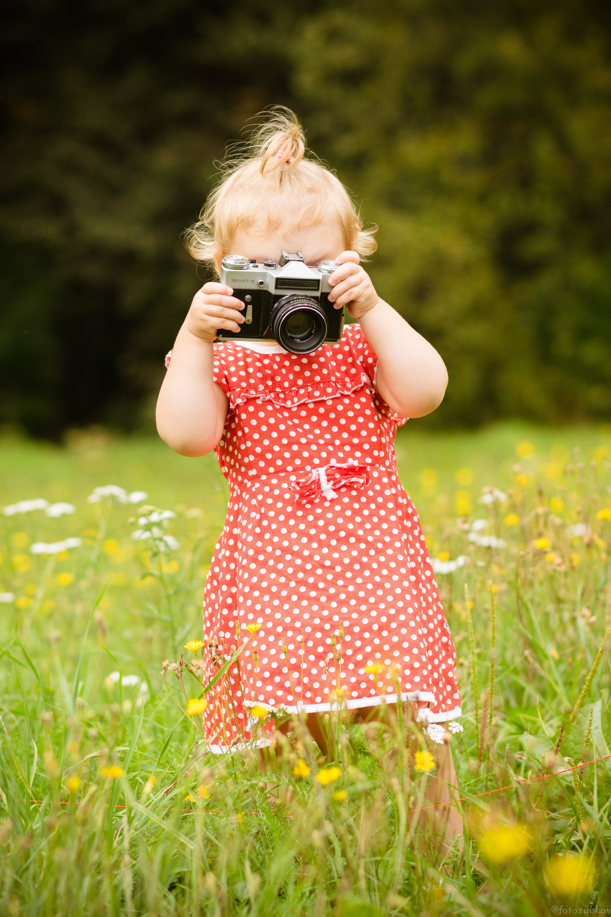 Красивый ребенок держит фотоаппарат 
