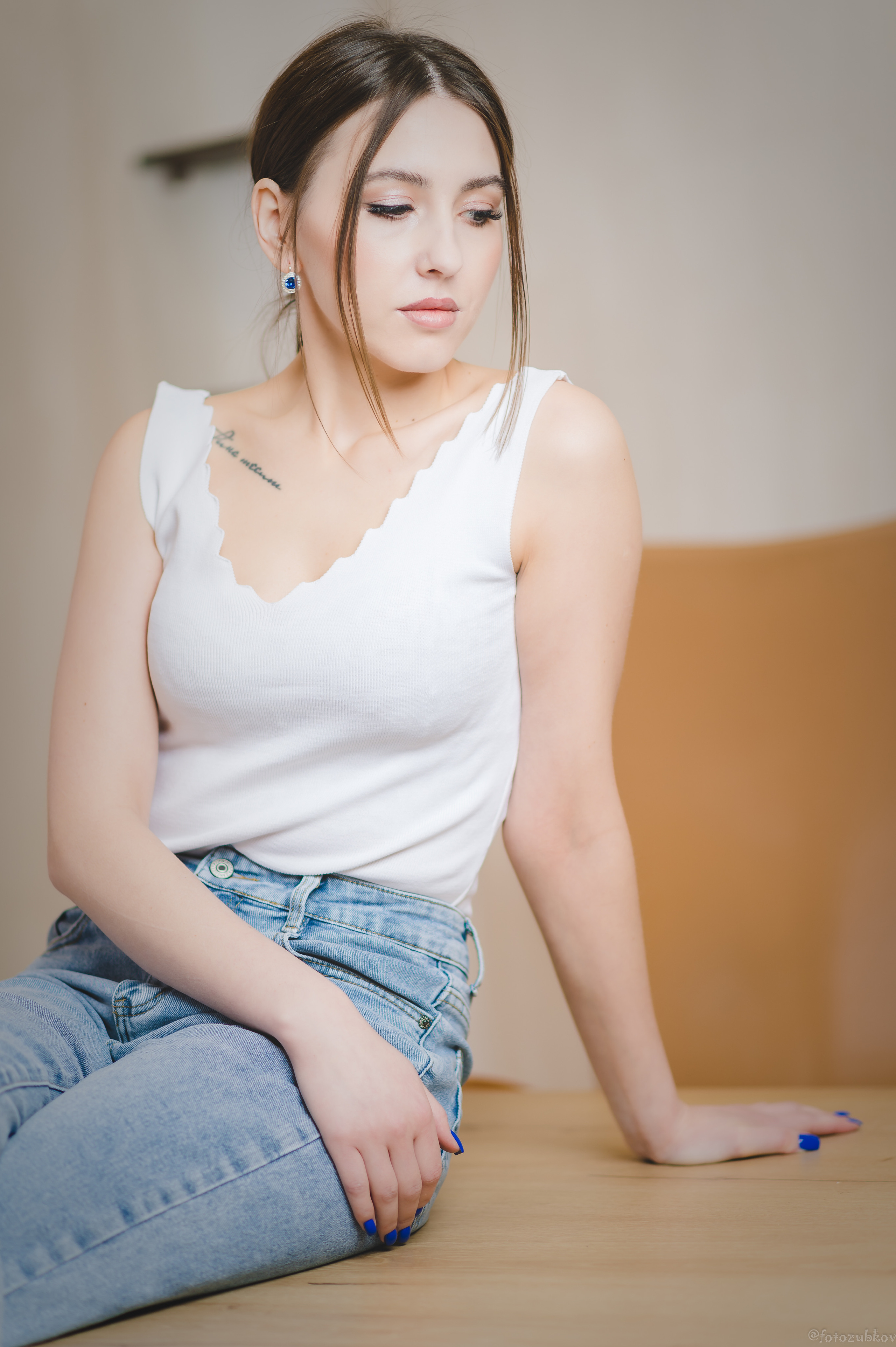 Задумчивая девушка сидит на столе