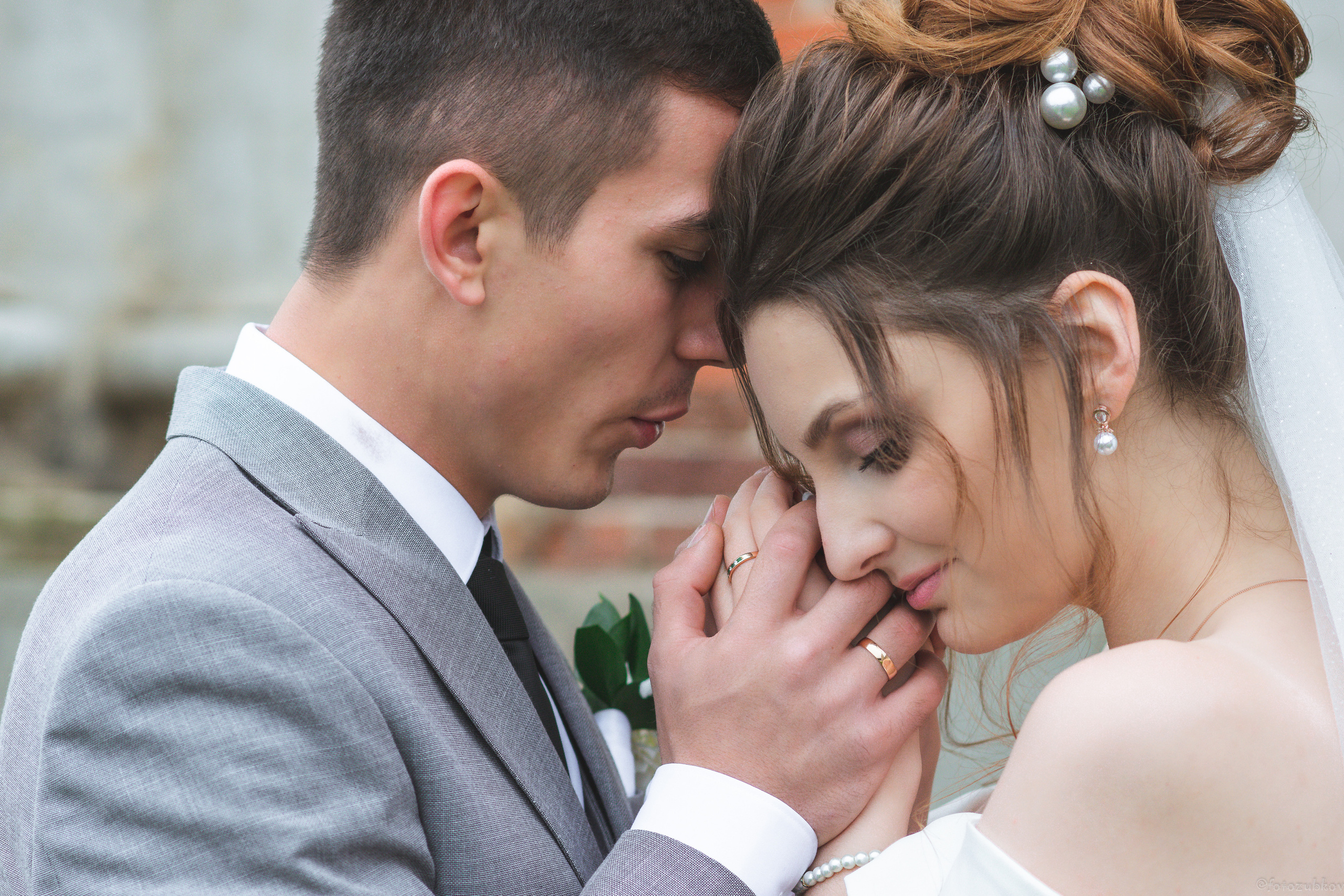 Жених греет руки невесты в платье