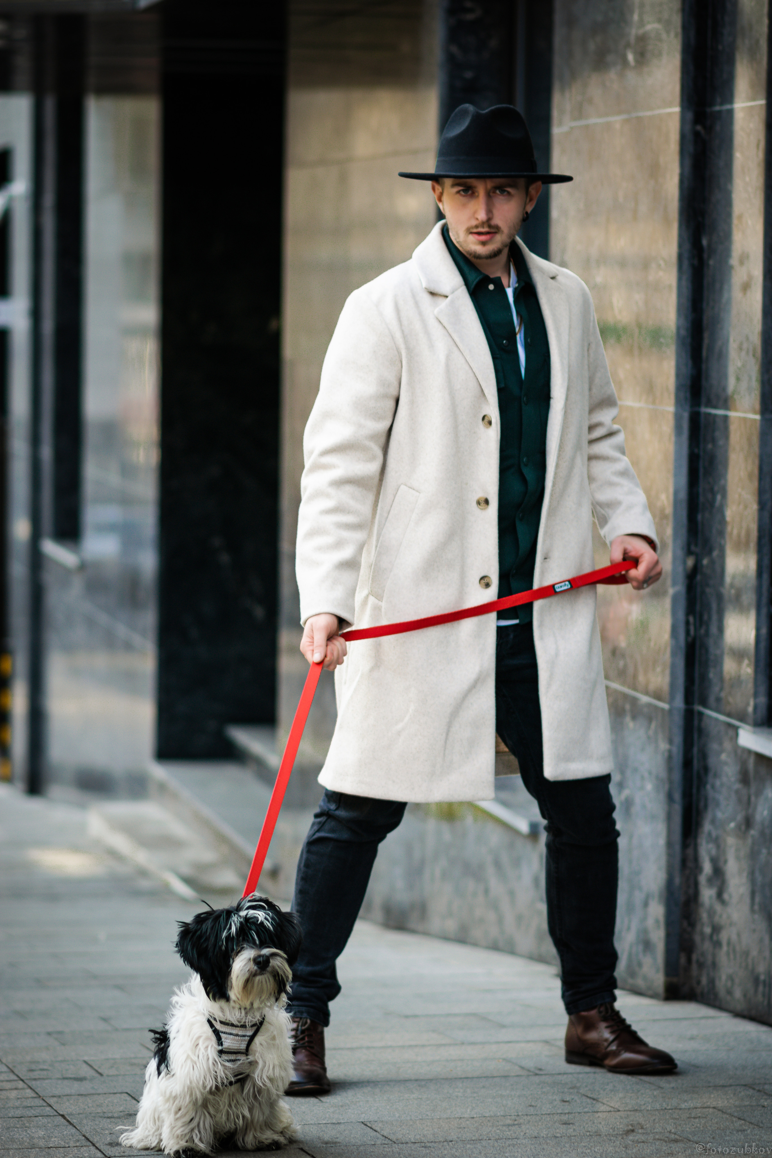 Молодой человек в белом пальто и шляпе с собачкой