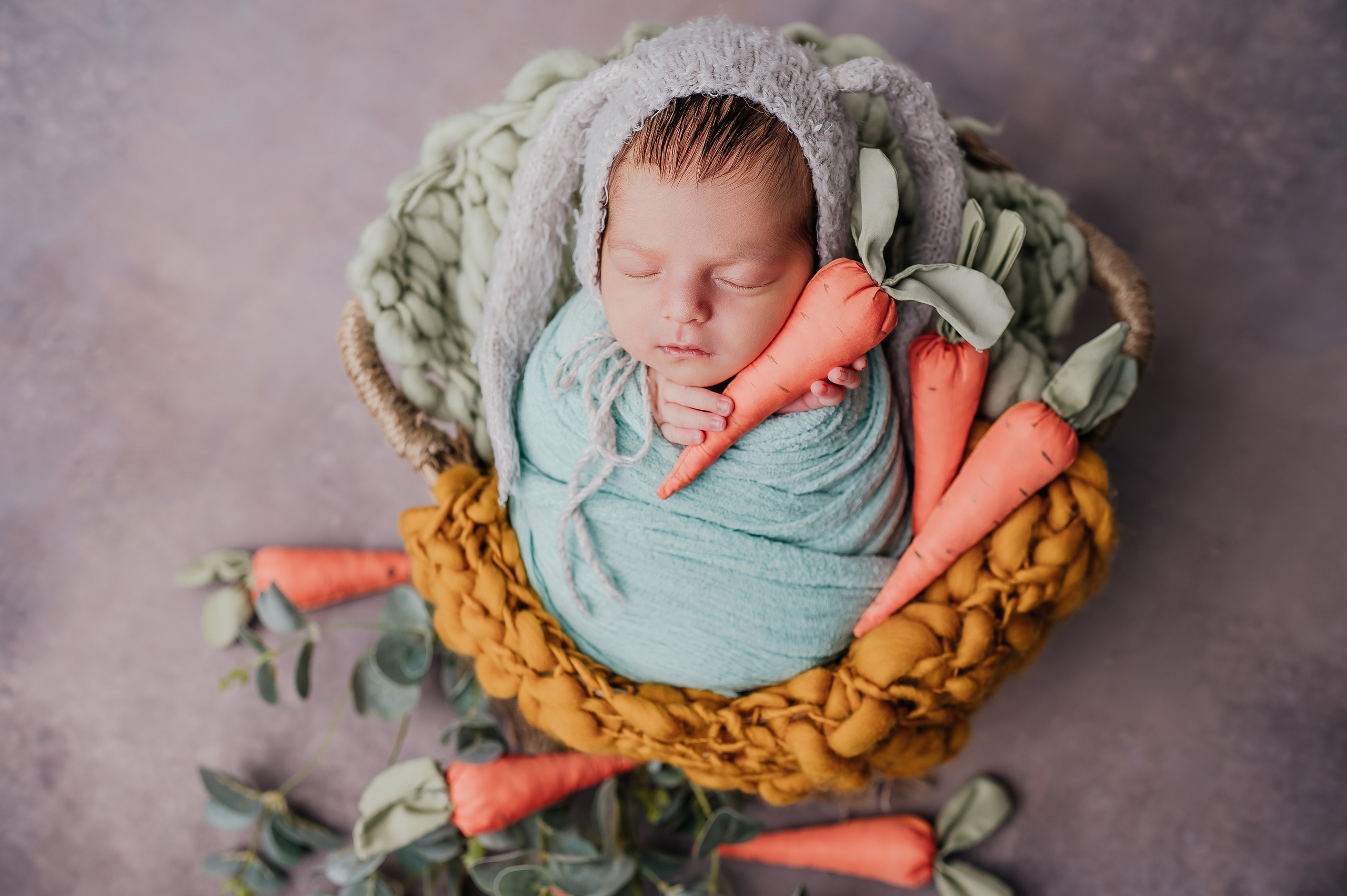 Новорожденный малыш в образе зайчика в позировке кокон