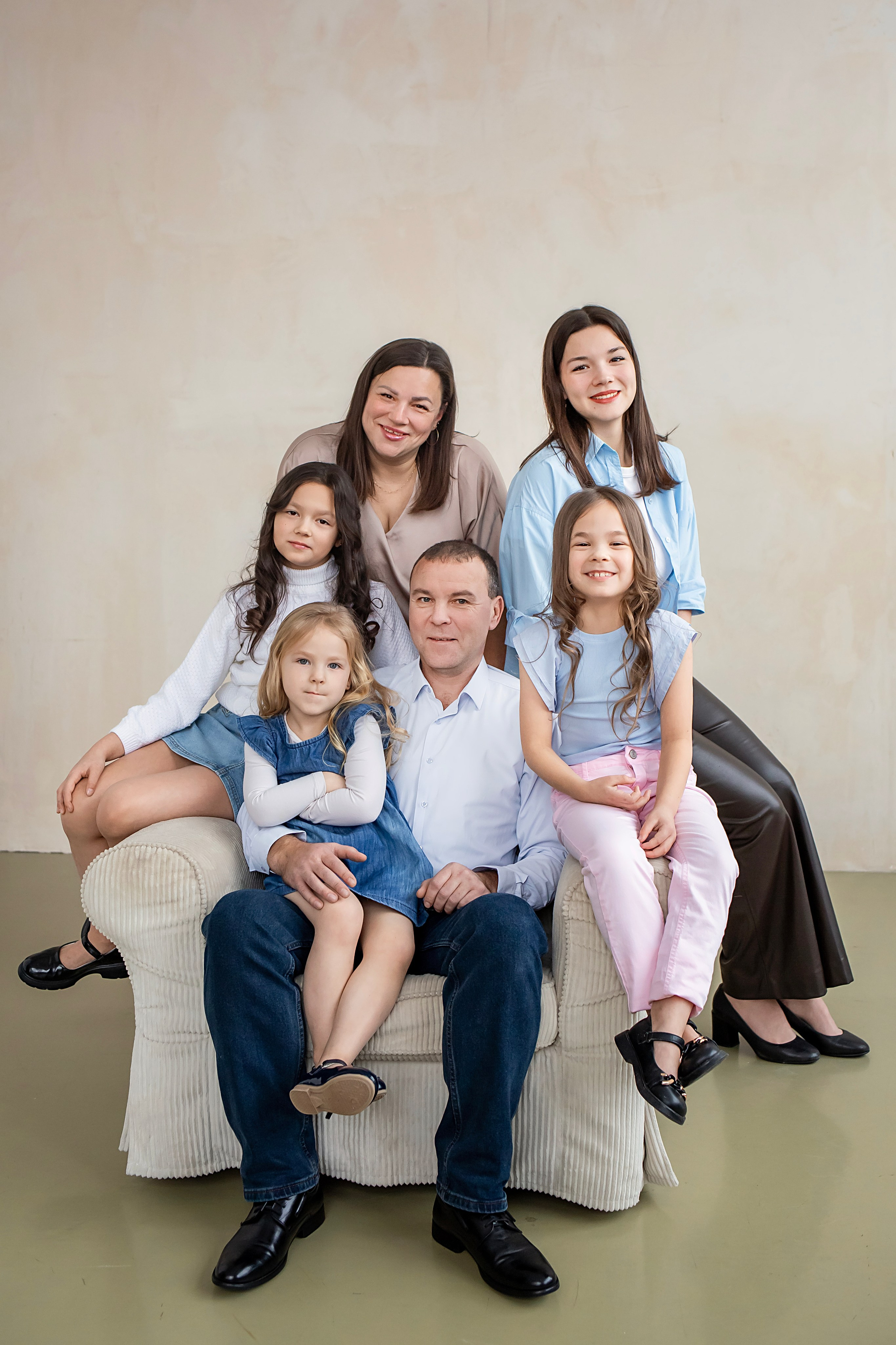 Счастливая многодетная семья на кресле в студии