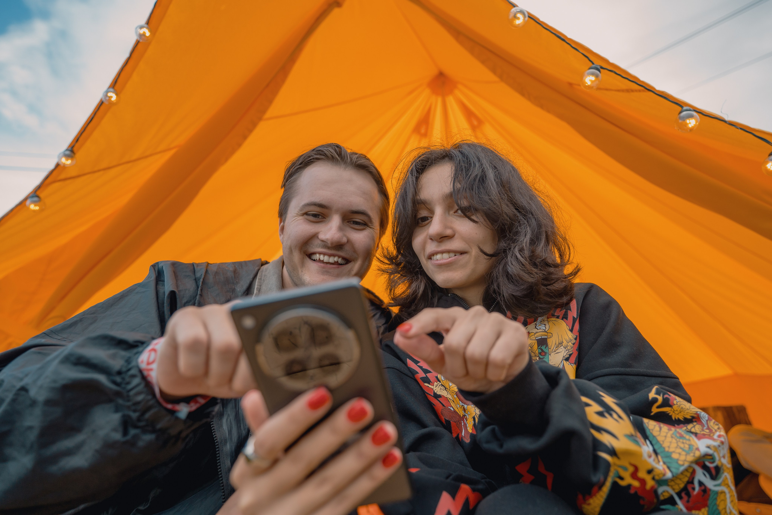 Крупное фото пары  которая смотрит на телефон Infinix Zero