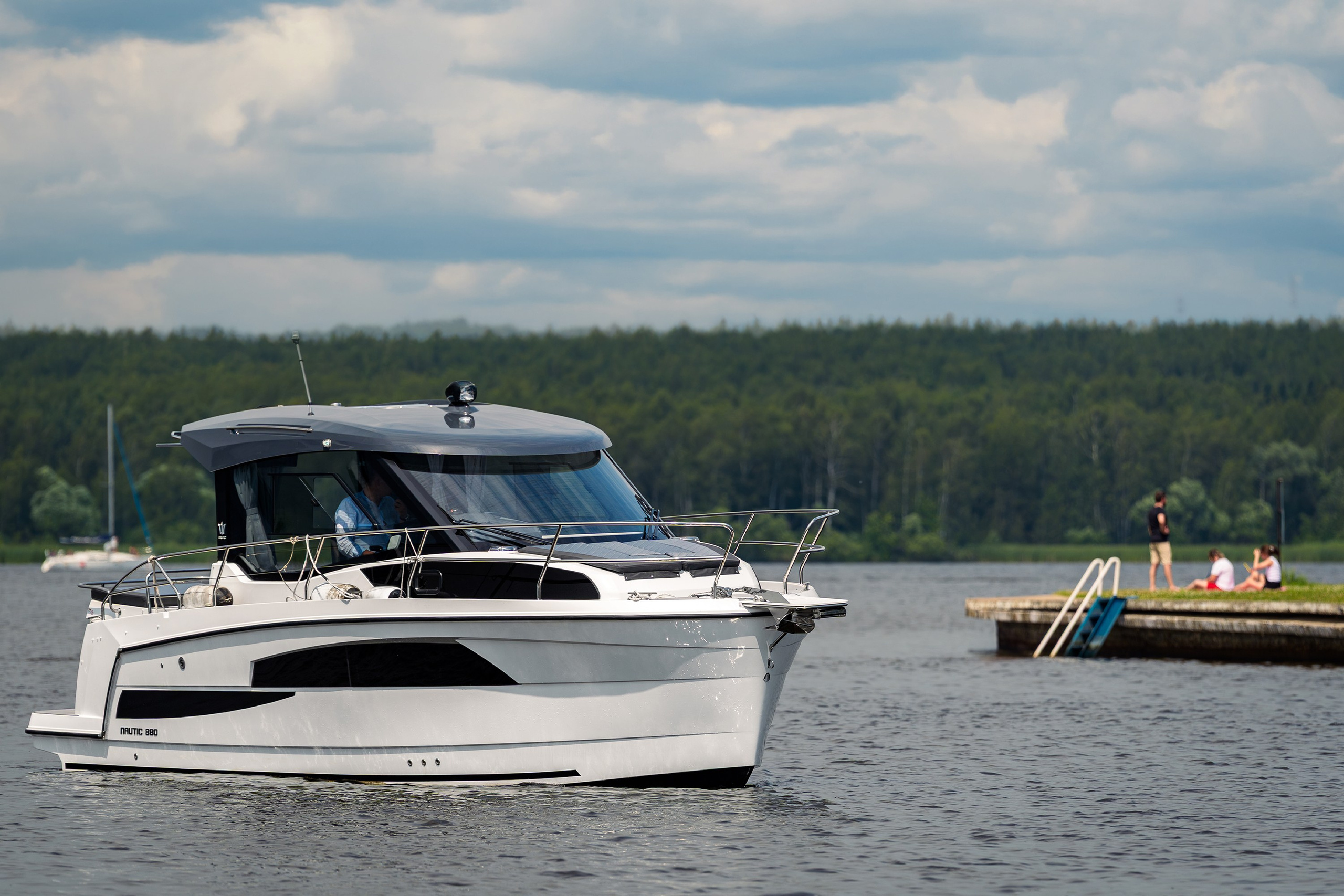 Катер Nautic 880 у причала, фотосъёмка фронтального вида корпуса и рубки