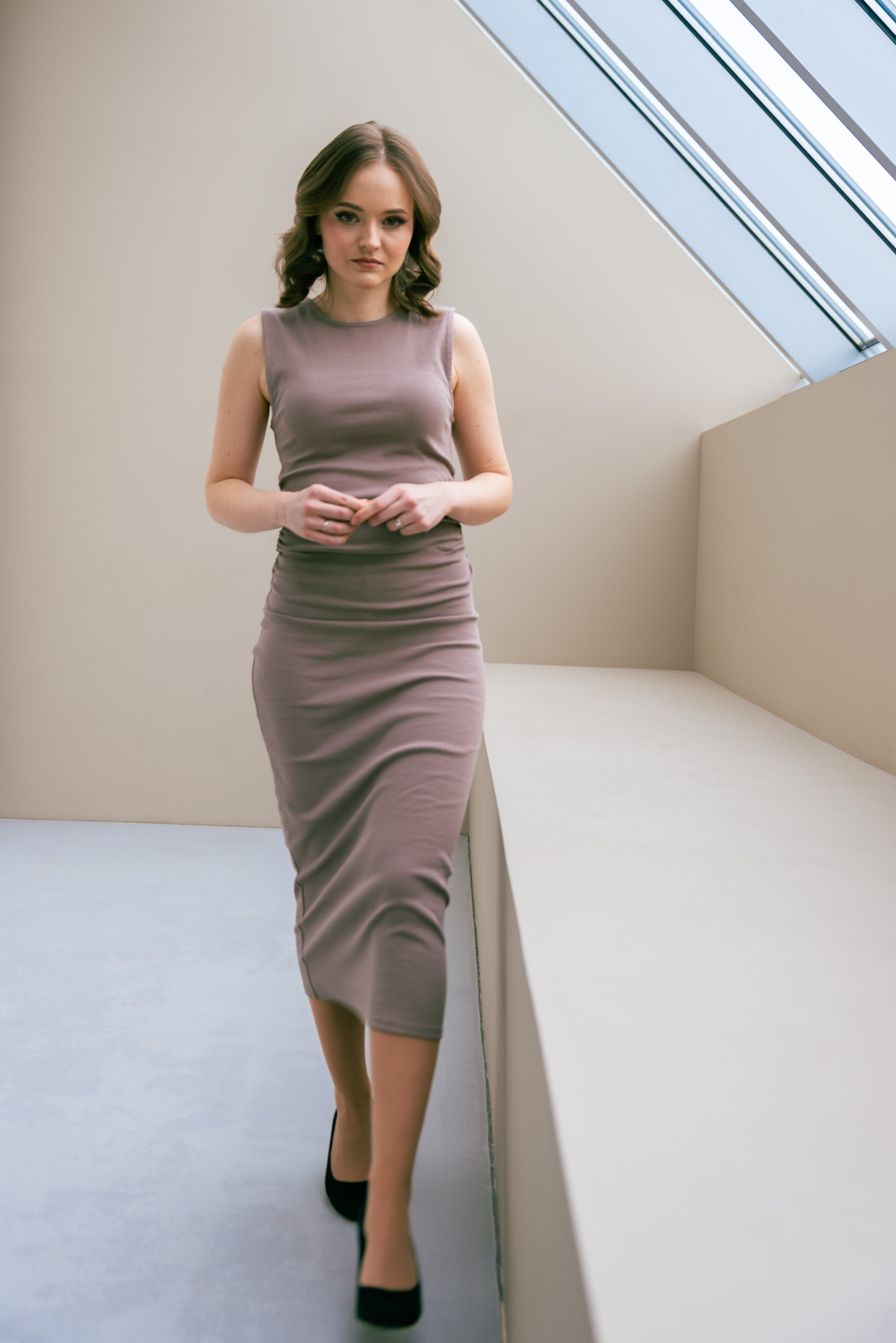 Фотостудия, естественный свет. Девушка в длинном платье идёт вдоль мансардного окна. 