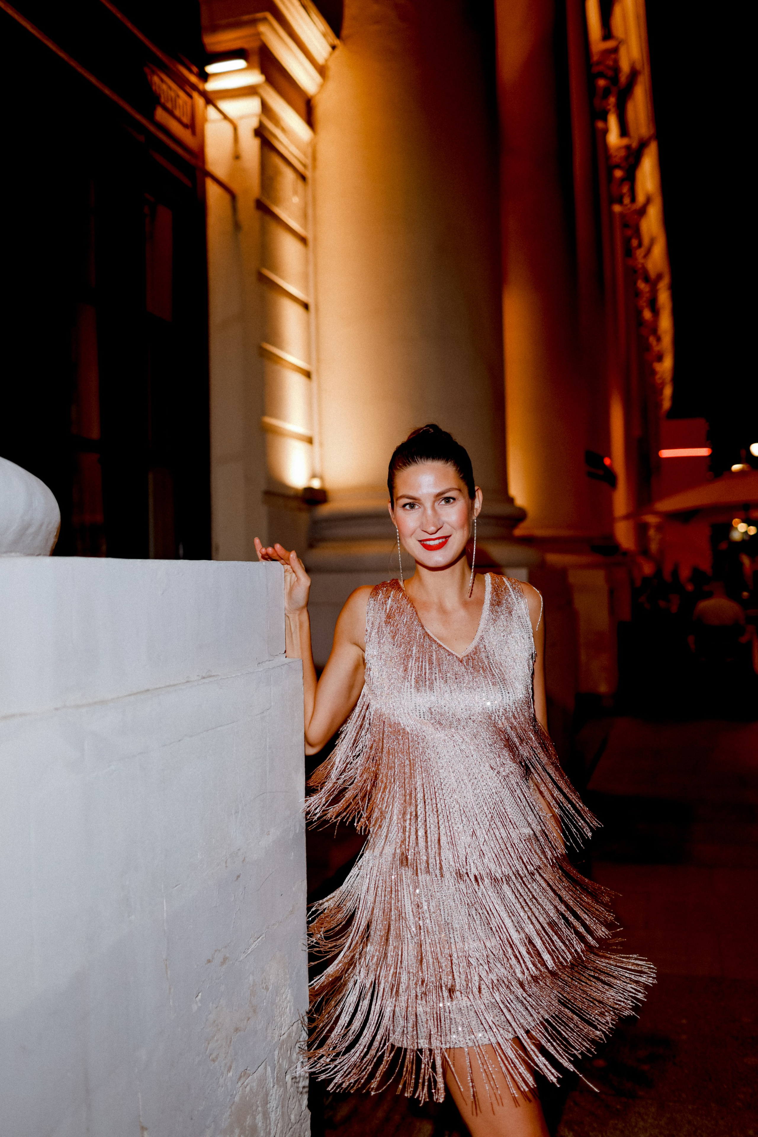 <img src="IZ0A0352.jpg" alt="Красивая девушка в платье  с бахромой стоит около колонны ночью в центре Москвы возле здания ГУМа">