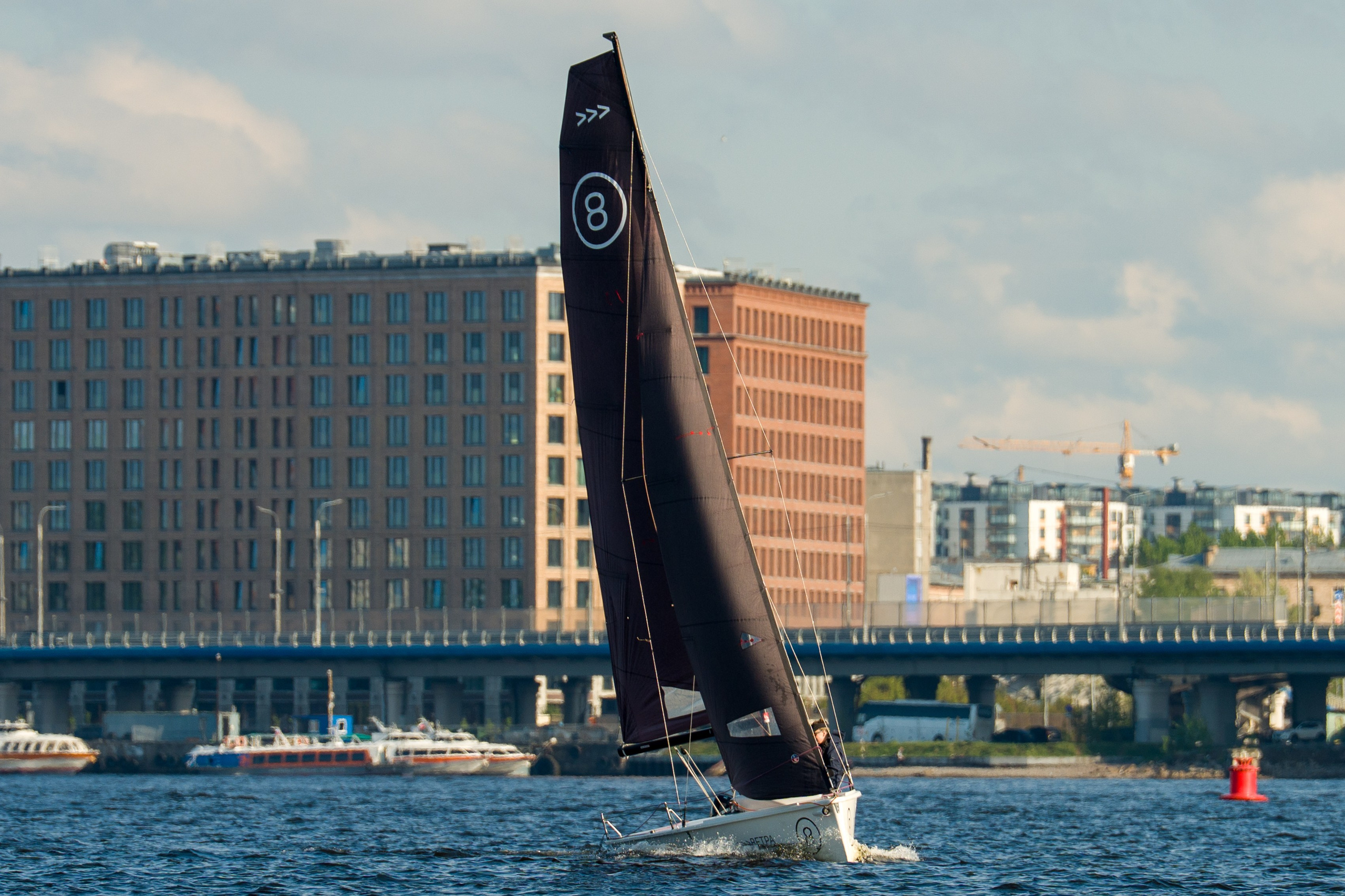 SV20 heels hard on a full sail, crew trims sheets tight