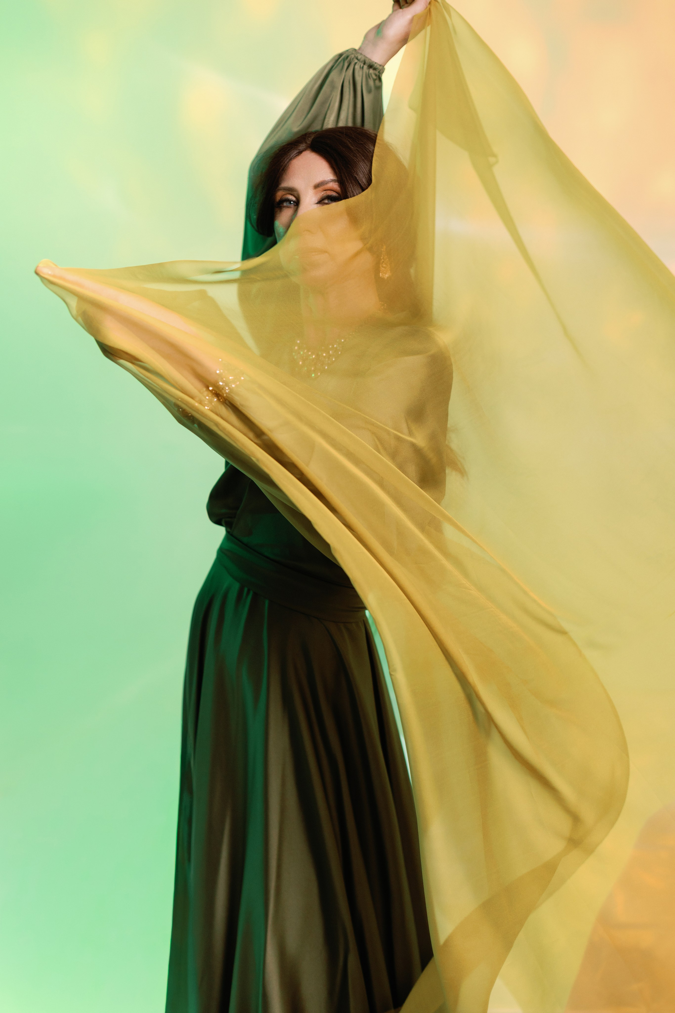 На фотографии изображена девушка держащая в руках развивается платок. Фотосессия в арабском стиле в студии Ростова