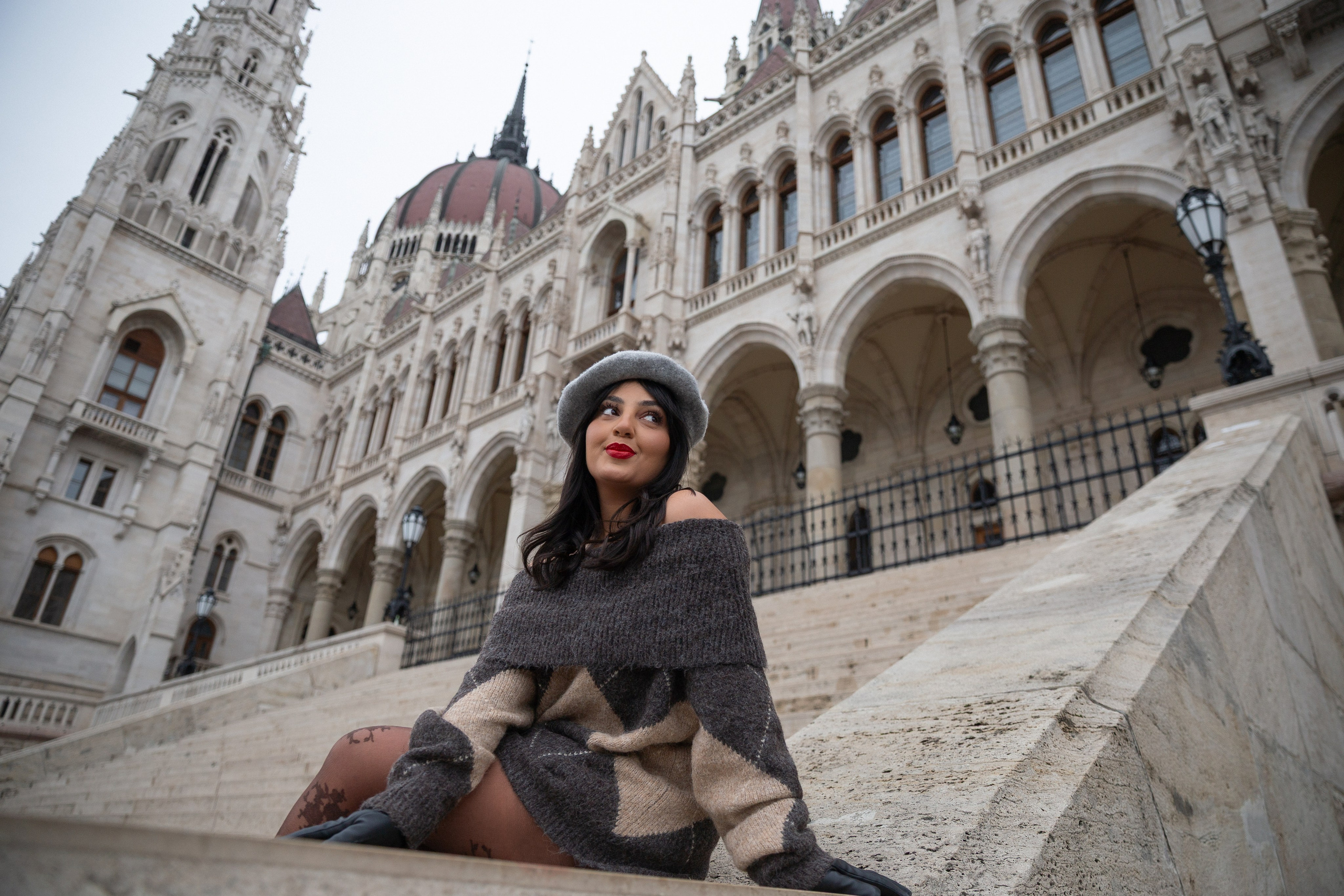 A photograph of a girl in front of the Hungarian Parliament