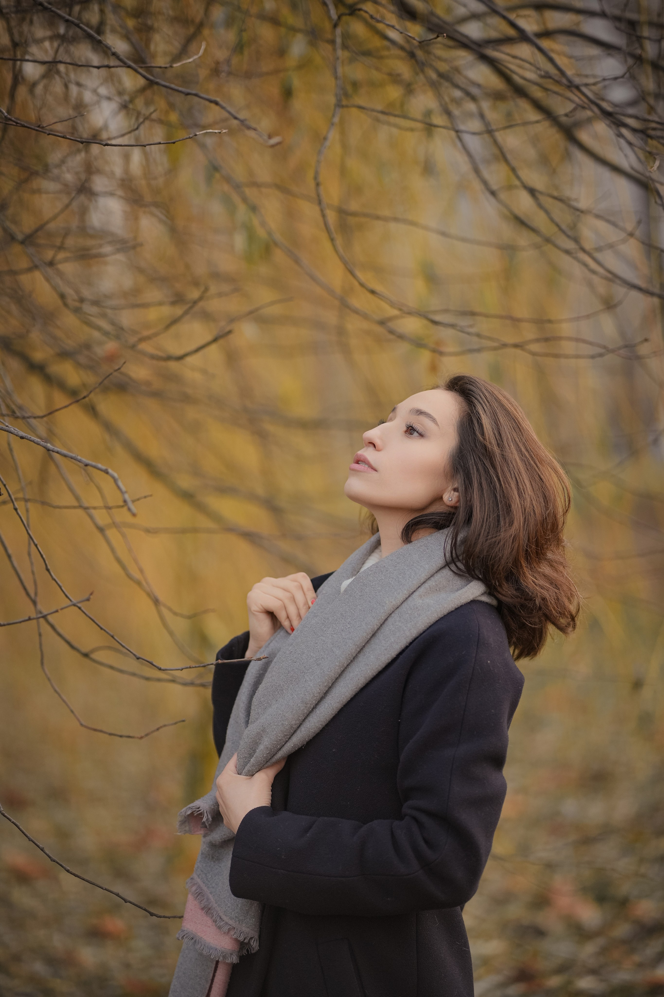 портрет в анфас брюнетки девушки в пальто в осеннем парке