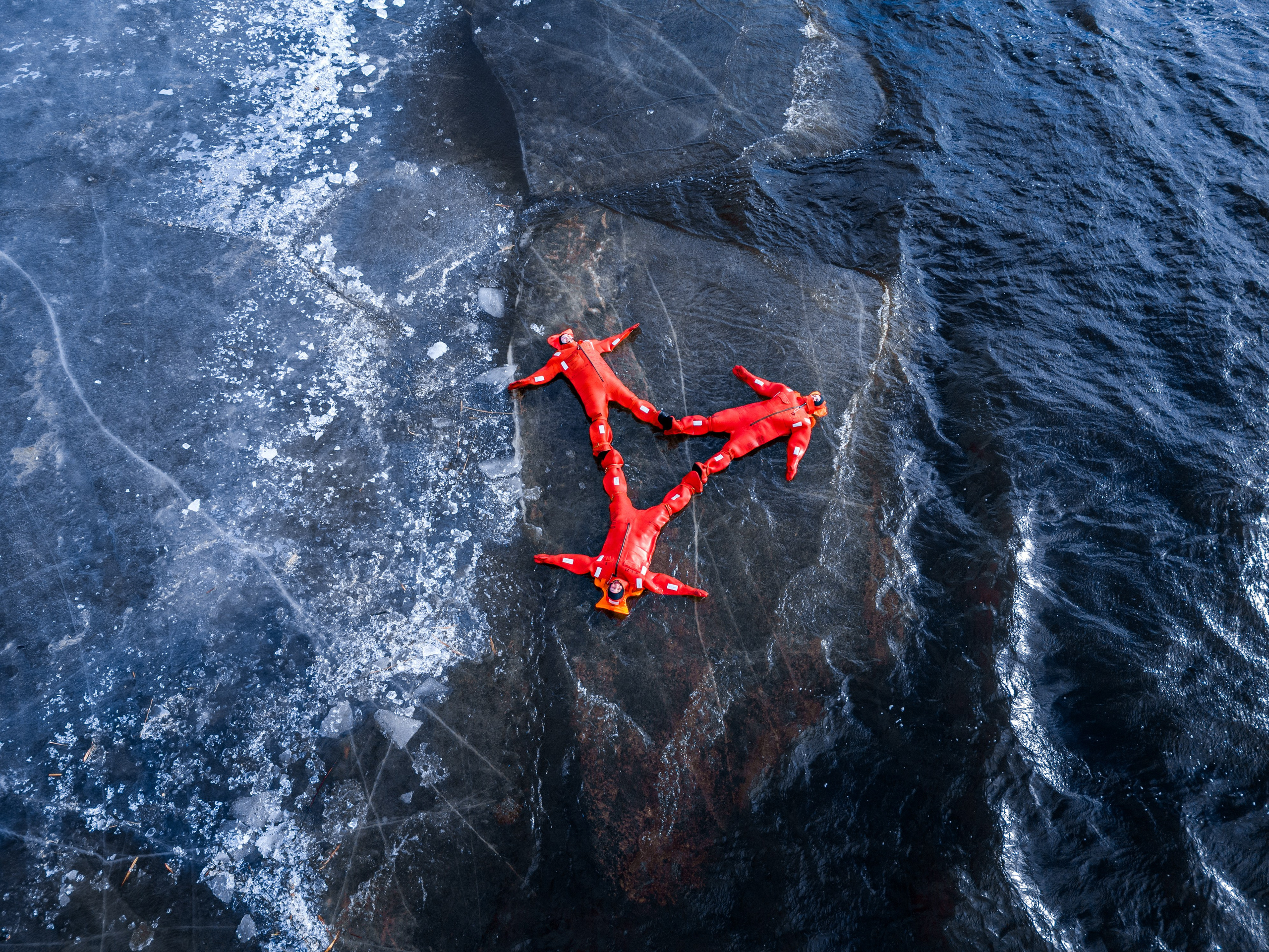 Люди купаются среди льдин, в спасательных оранжевых термо костюмах, айс флоатинг Ярославль