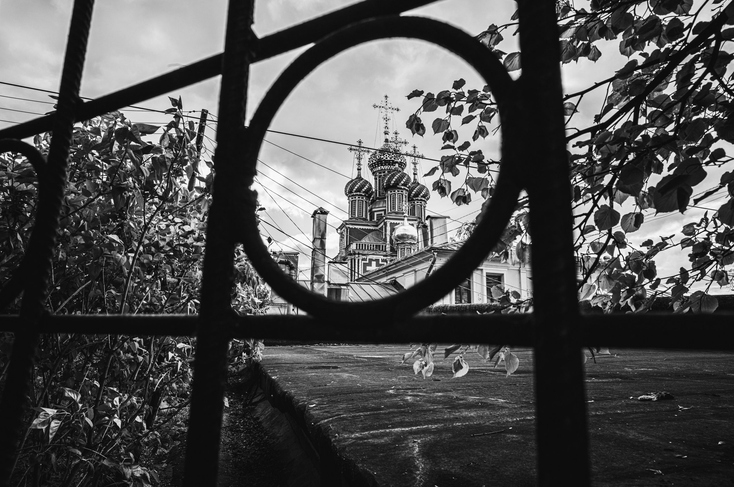 Вид на купола церкви сквозь круглое видовое отверстие в ограде в Нижнем Новгороде 