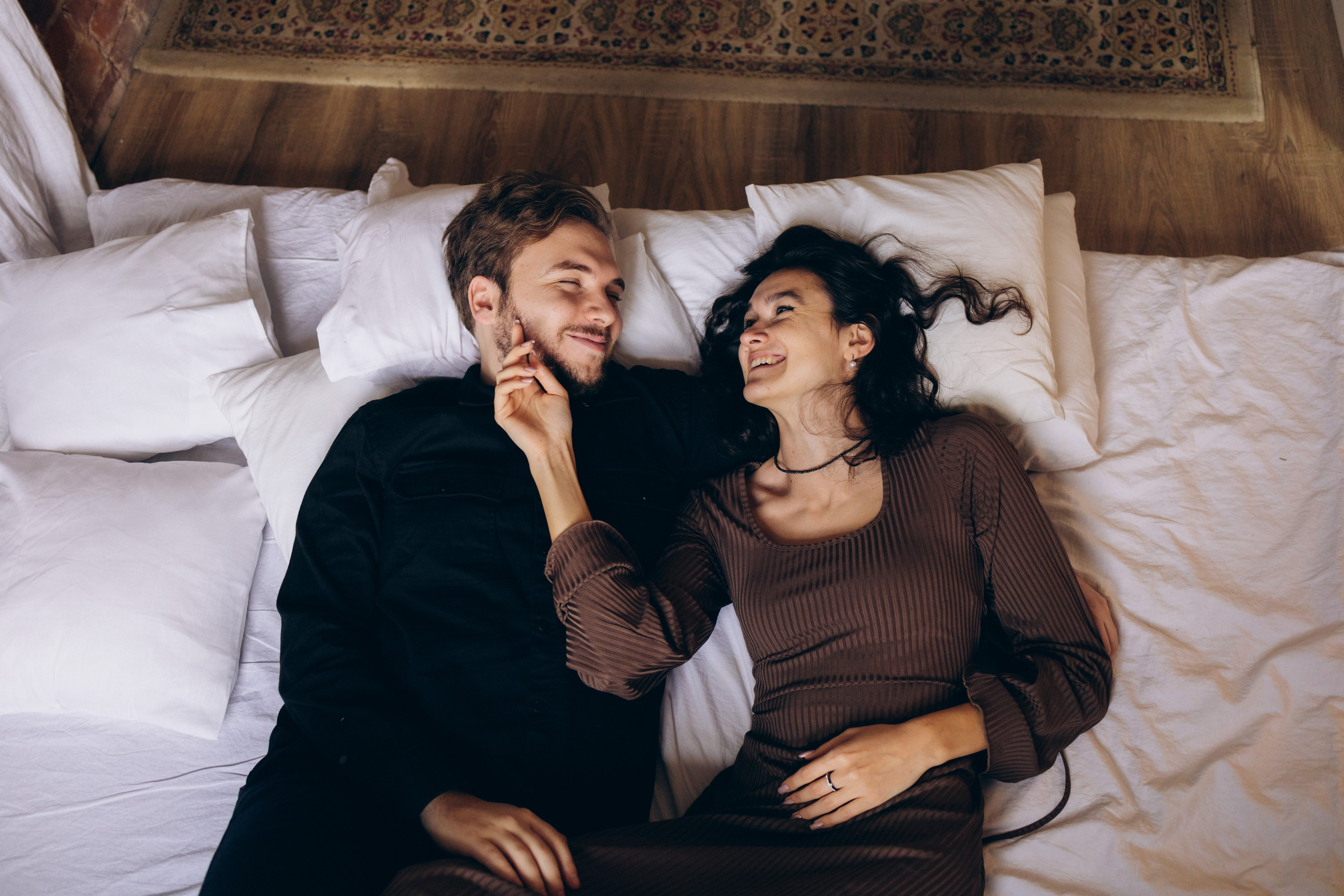 Искренние эмоции: девушка смеется, обнимая своего парня на студийной фотосессии