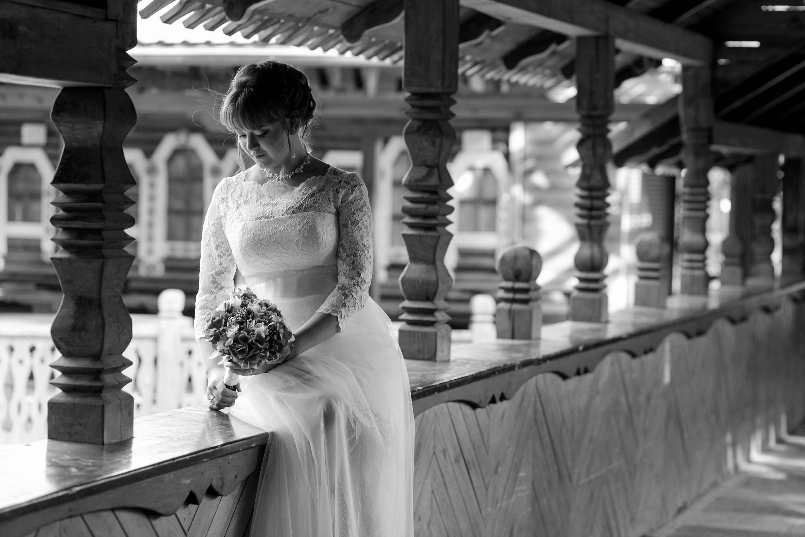 Невеста сидит и смотрит на свой свадебный букет