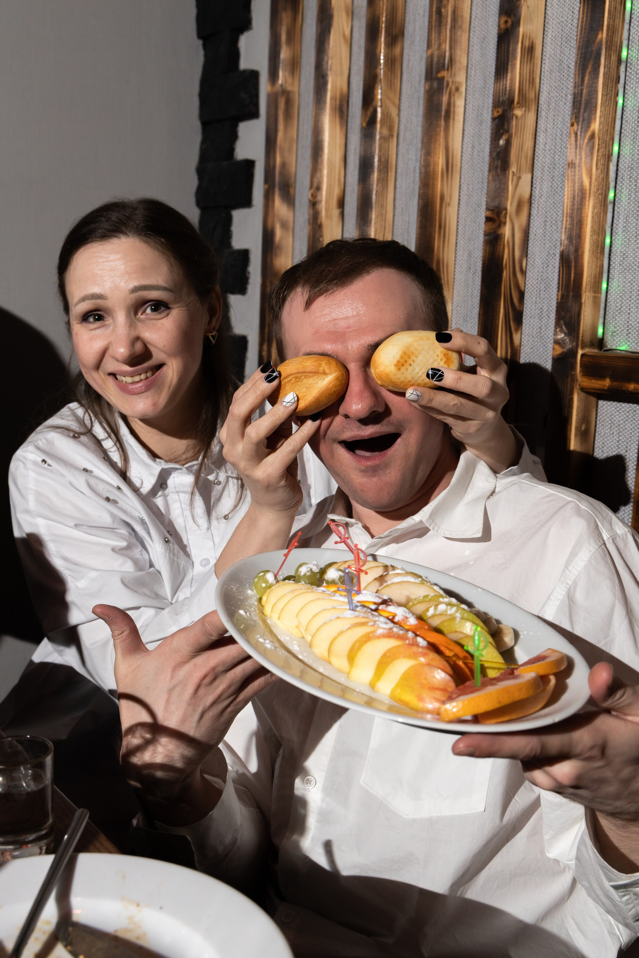 Мужчина и женщина за столом, в руках держат еду. День рождения  Астрахань.