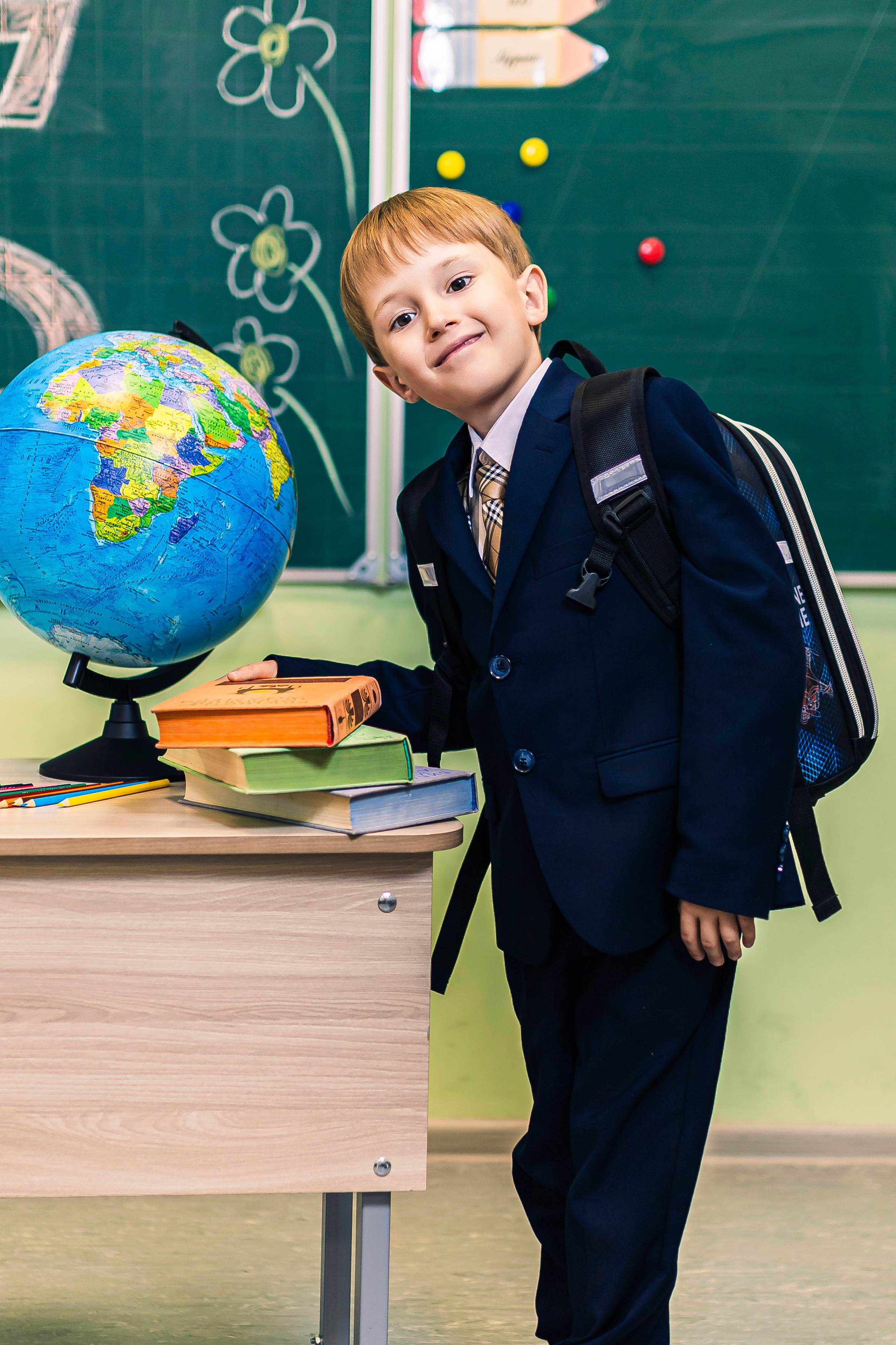 мальчик стоит возле парты 