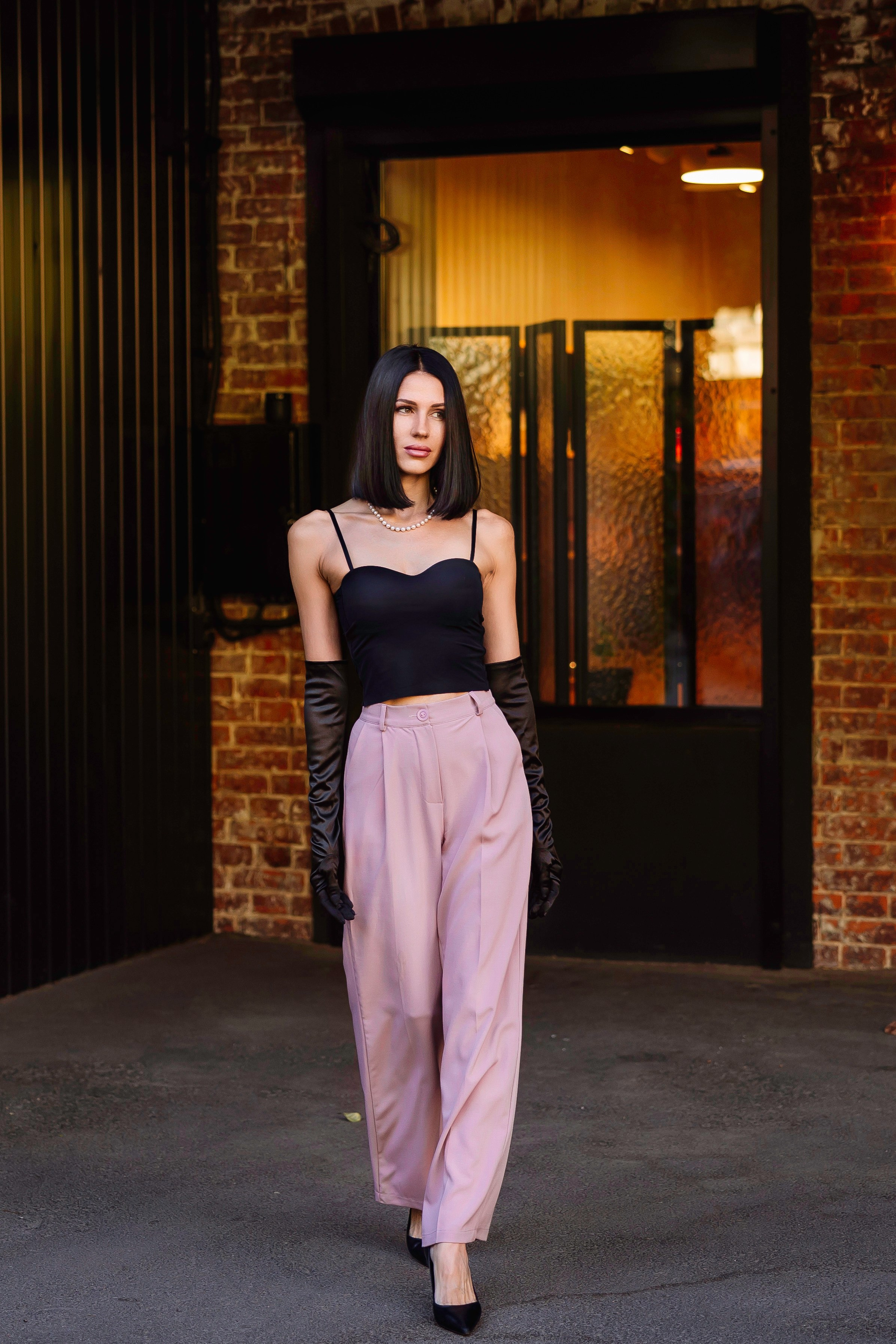 Портрет девушки в розовыx брюках и перчатках